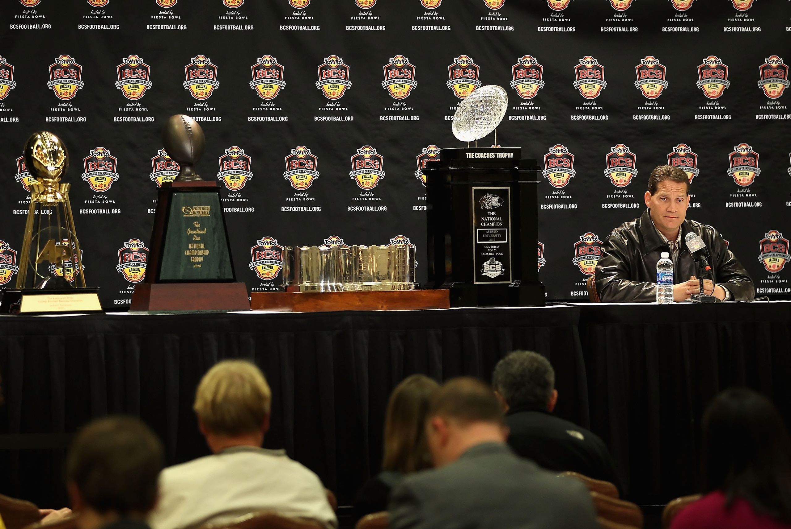 SCOTTSDALE, AZ - JANUARY 11:  Head coach Gene Chizik of the Auburn Tigers sits with the (L-R) Associated Press, Football Writers of America, MacArthur Bowl and the Coaches trophys during a press conference for the Tostitos BCS National Championship Game a
