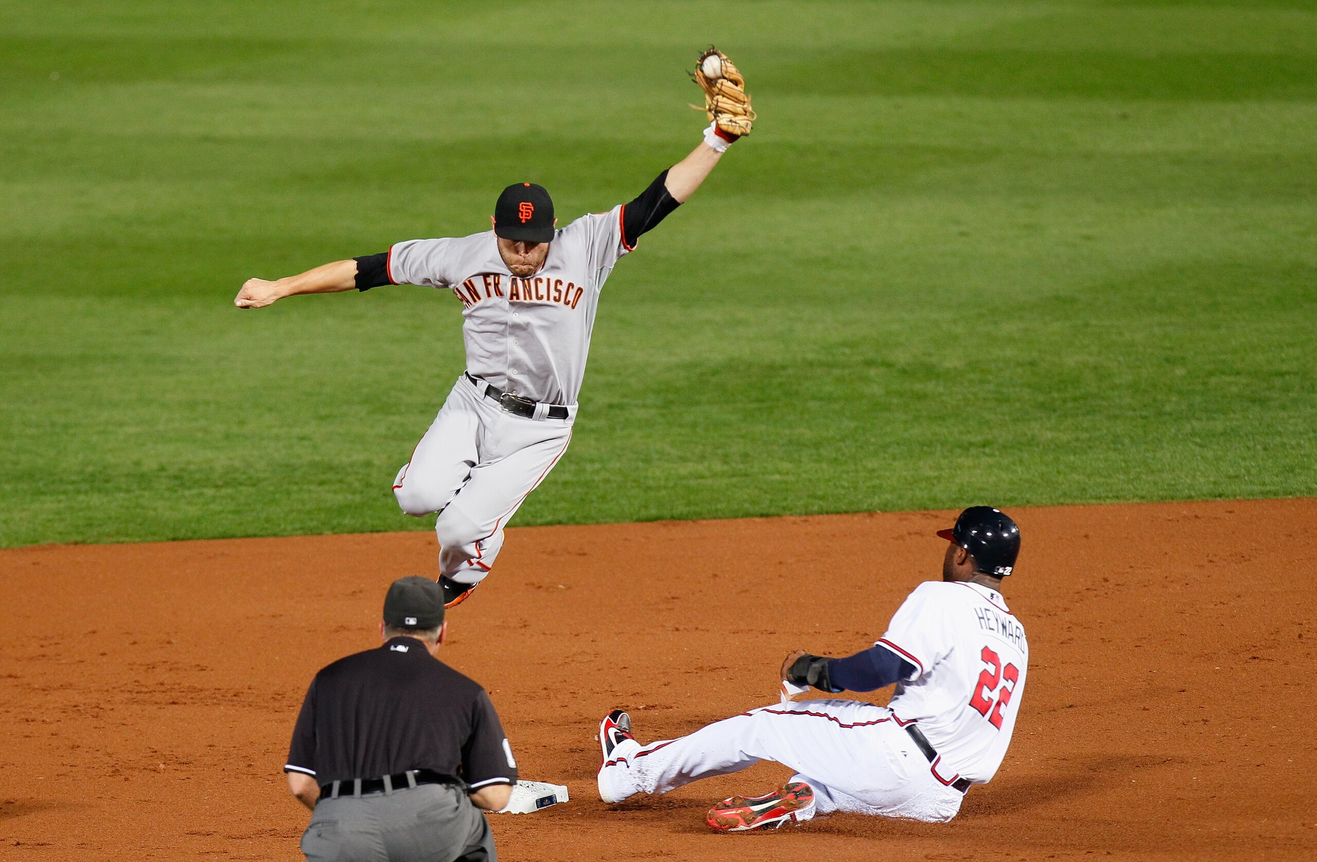 ATLANTA - OCTOBER 11: Jason Heyward #22 of the Atlanta Braves slides in safely under a leaping Freddy Sanchez #21 of the San Francisco Giants in the second inning during Game Four of the NLDS of the 2010 MLB Playoffs at Turner Field on October 11, 2010 i ATLANTA - OCTOBER 11: Jason Heyward #22 of the Atlanta Braves slides in safely under a leaping Freddy Sanchez #21 of the San Francisco Giants in the second inning during Game Four of the NLDS of the 2010 MLB Playoffs at Turner Field on October 11, 2010 i