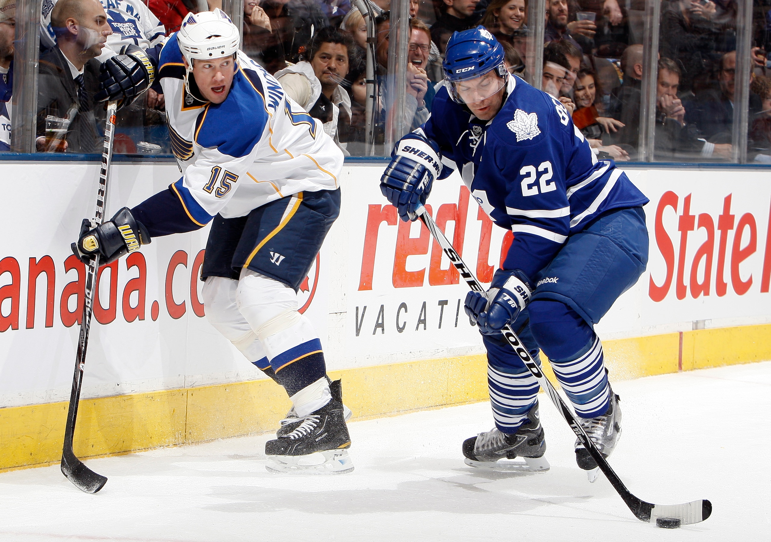 TORONTO, CANADA - JANUARY 6: Francois Beauchemin #22 of the Toronto Maple Leafs passes the puck away from Brad Winchester #15 of the St. Louis Blues during game action at the Air Canada Centre January 6, 2011 in Toronto, Ontario, Canada. (Photo by Abelima