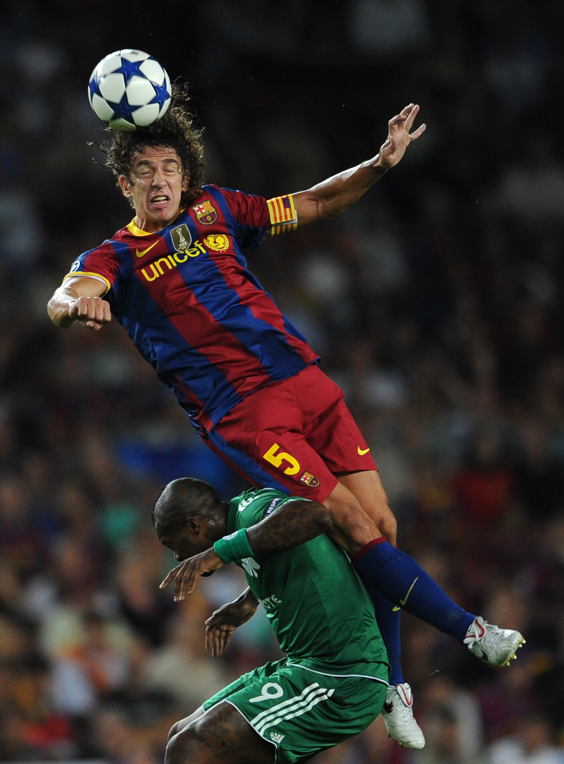 BARCELONA, SPAIN - SEPTEMBER 14:  Carles Puyol of Barcelona duels for a high ball with Djibril Cisse of Panathinaikos during the UEFA Champions League group D match between Barcelona and Panathinaikos on September 14, 2010 in Barcelona, Spain. Barcelona w