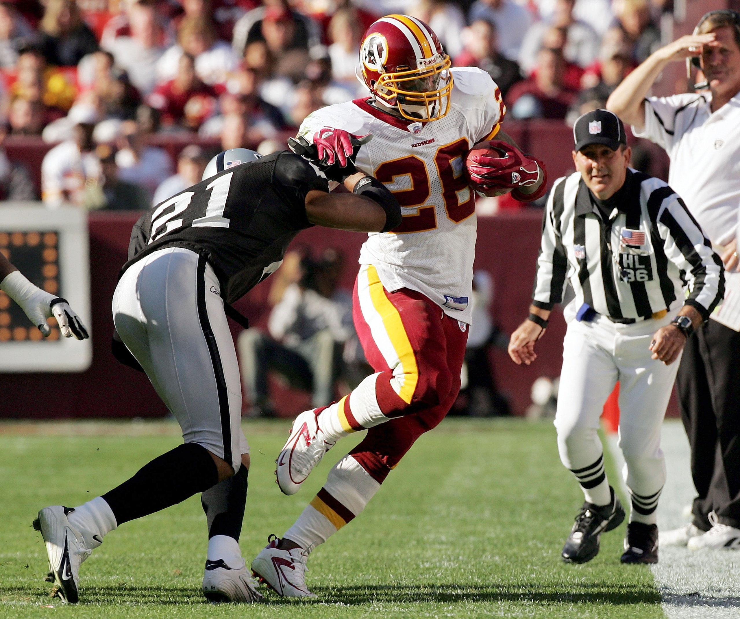 WASHINGTON - NOVEMBER 20:  Washington Redskins running back Clinton Portis #26 is tackled by Oakland Raiders cornerback Nnamdi Asomugha #21 during their game on November 20, 2005 at Fed Ex Field in Landover, Maryland.  (Photo by Win McNamee/Getty Images)