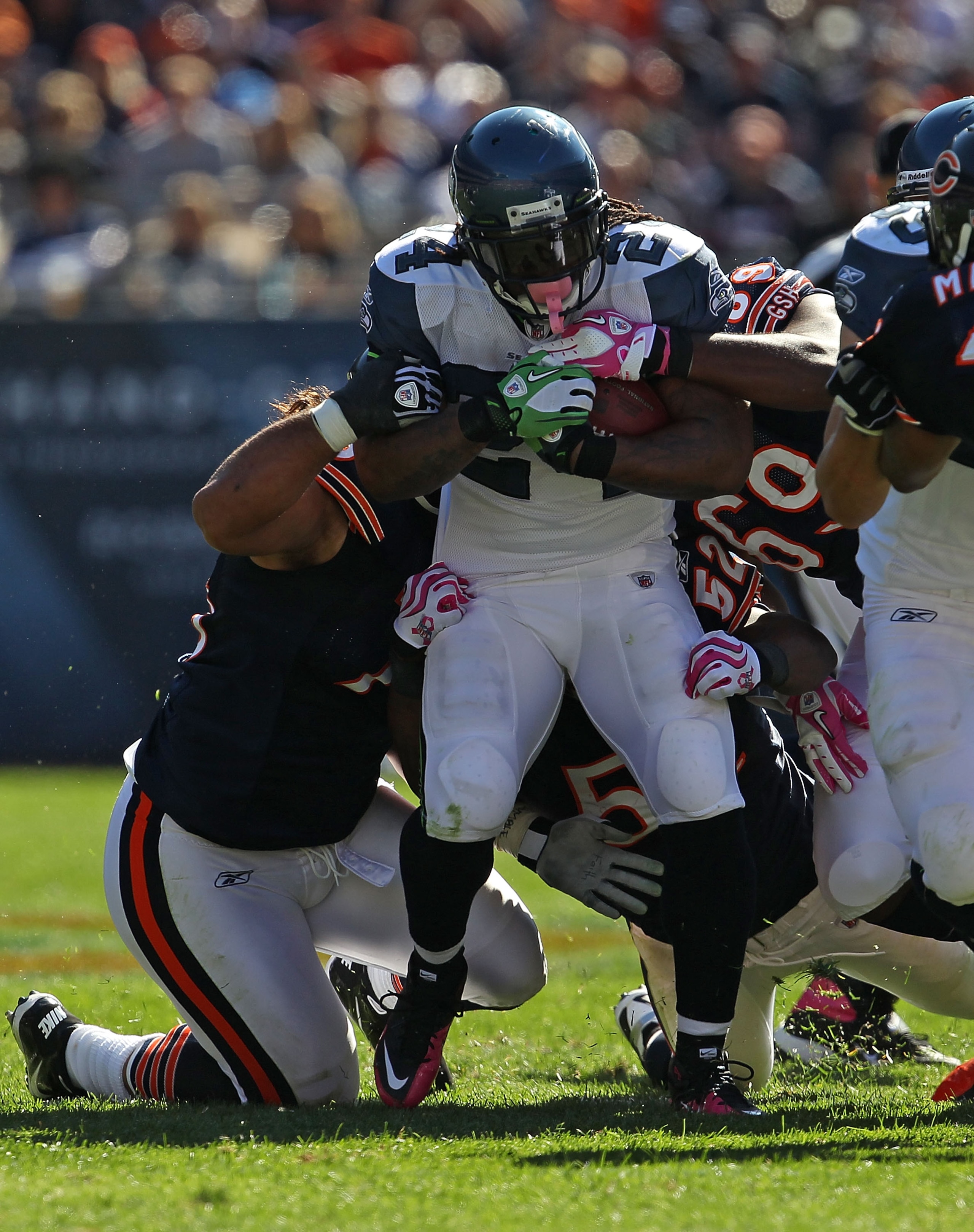 CHICAGO - OCTOBER 17: Marshawn Lynch #24 of the Seattle Seahawks is stopped by Matt Toeaina #75 (L) and Henry Melton #69 of the Chicago Bears at Soldier Field on October 17, 2010 in Chicago, Illinois. The Seahawks defeated the Bears 23-20.  (Photo by Jona