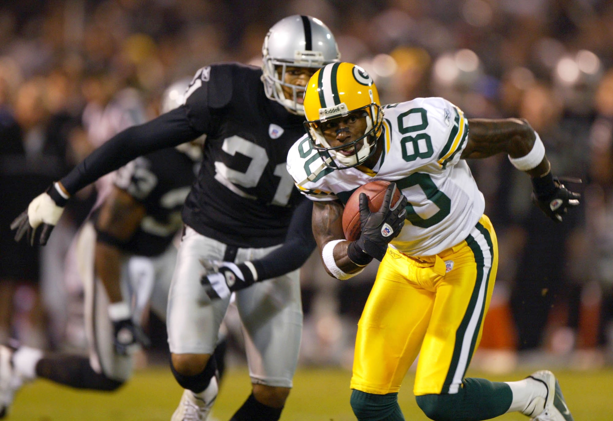 OAKLAND, CA - DECEMBER 22:  Donald Driver #80 of the Green Bay Packers runs with the ball as Nnamsi Asomugha #21 of the Oakland Raiders defends during an NFL game on December 22, 2003  at the Network Associates Coliseum in Oakland, California.  (Photo by