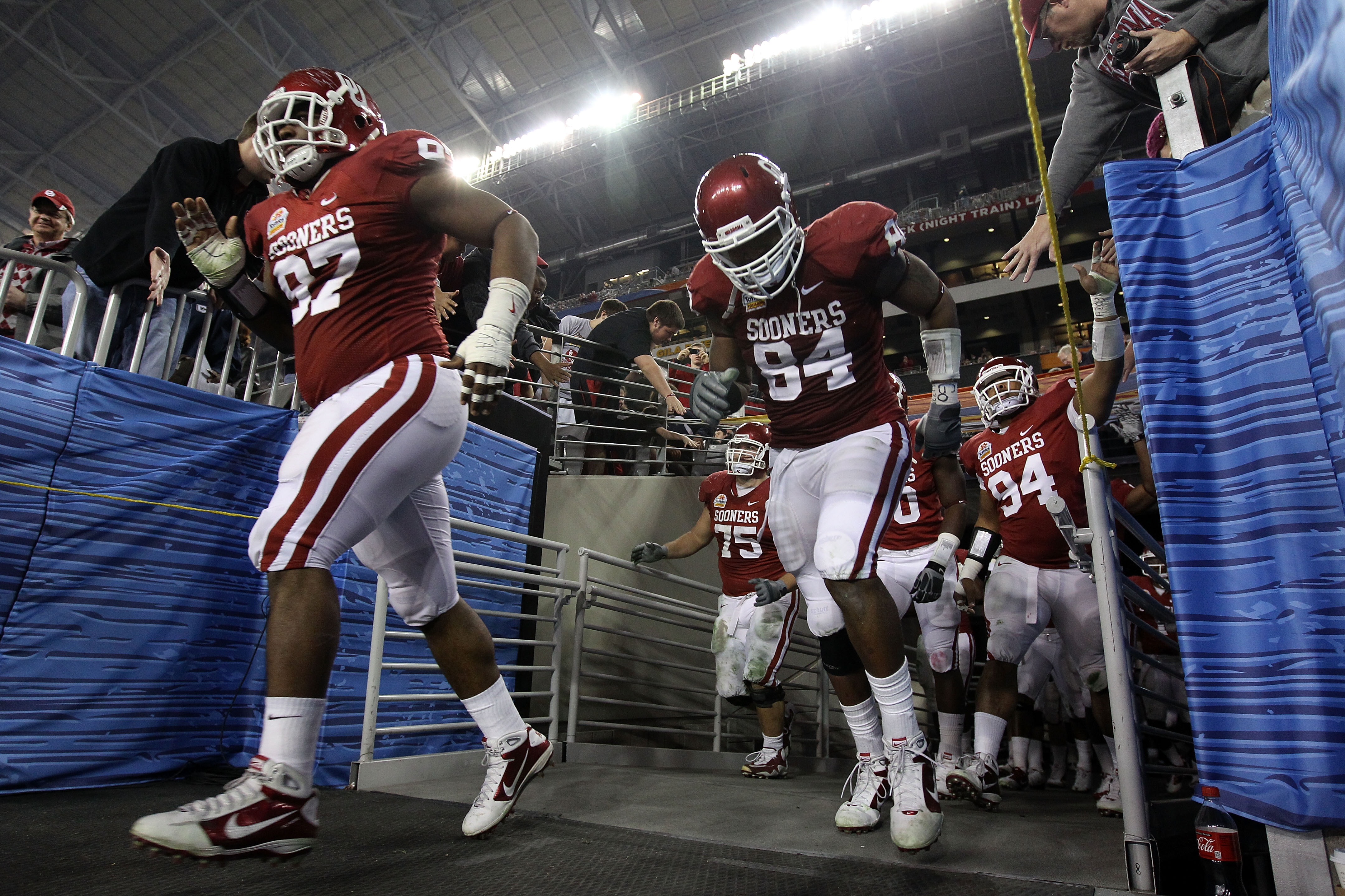 GLENDALE, AZ - JANUARY 01:  Jamarkus McFarland #97 and Pryce Macon #94 of the Oklahoma Sooners run out of the tunnel after the half to take on the Connecticut Huskies  during the Tostitos Fiesta Bowl at the Universtity of Phoenix Stadium on January 1, 201