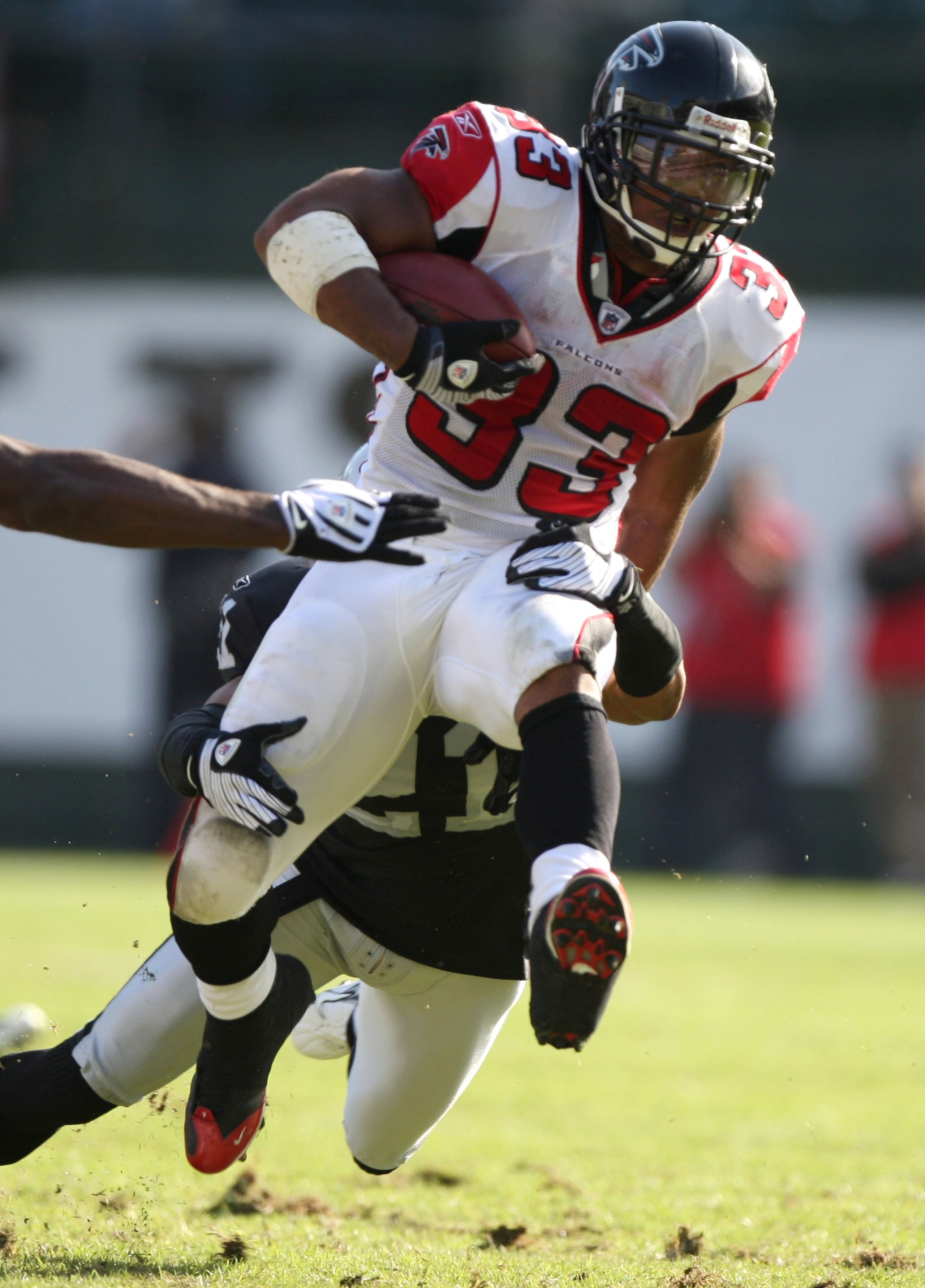OAKLAND, CA - NOVEMBER 02: Michael Turner #33 of the Atlanta Falcons runs with the ball as Nnamdi Asomugha #21 of the Oakland Raiders attempts to tackle him during an NFL game on November 2, 2008 at the Oakland-Alameda County Coliseum in Oakland, Californ