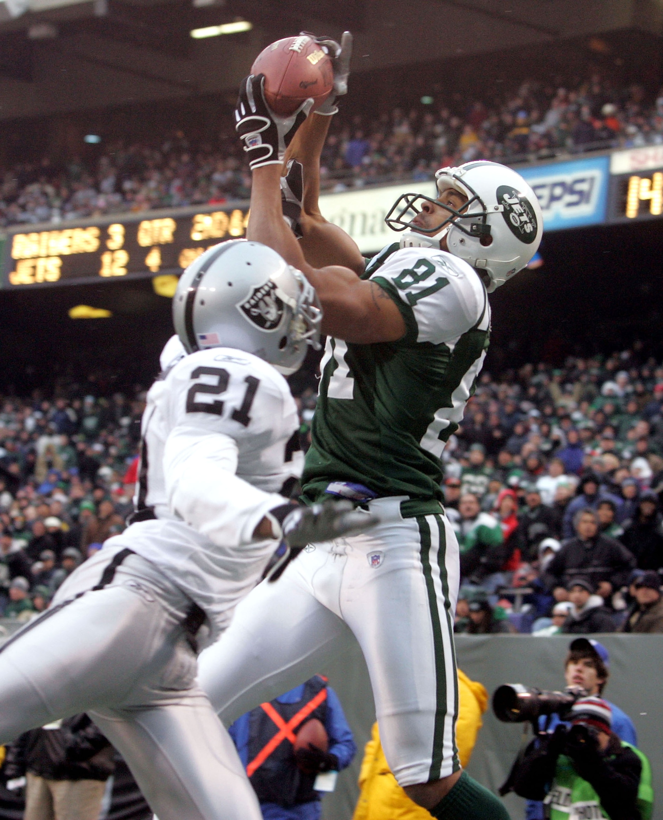 EAST RUTHERFORD, NJ - DECEMBER 11:  Wide receiver Justin McCareins #81 of the New York Jets catches a touchdown pass in the fourth quarter against cornerback Nnamdi Asomugha #21 of the Oakland Raiders on December 11, 2005 at Giants Stadium in East Rutherf