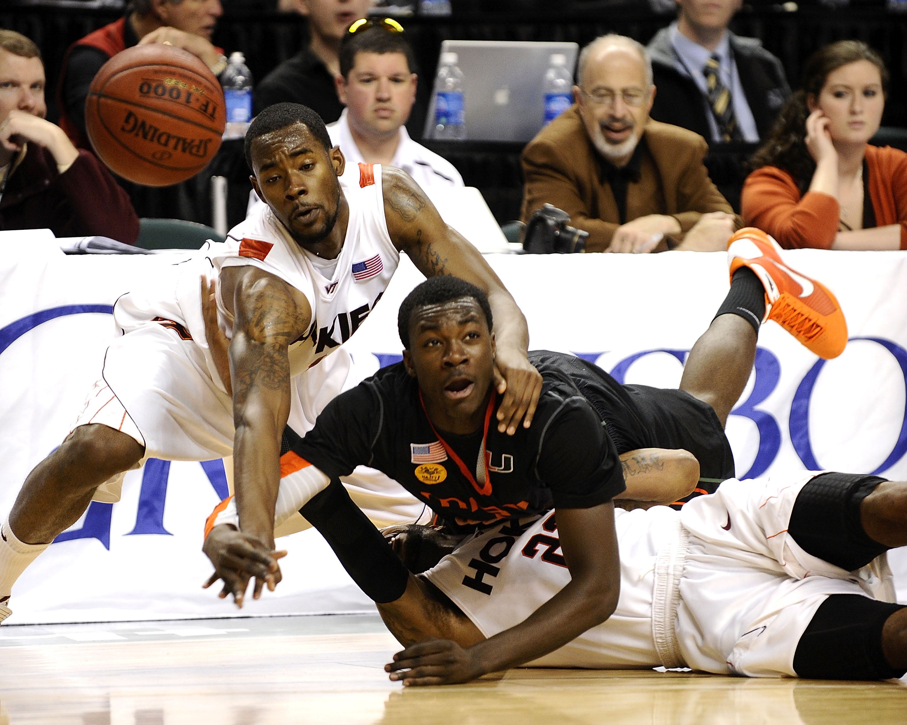 GREENSBORO, NC - MARCH 12: Malcolm Delaney #23 and Terrell Bell #1 of the Virginia Tech Hokies fights for a loose ball with Durand Scott #1 of the University of Miami Hurricanes in their quarterfinal game in the 2010 ACC Men's Basketball Tournament at t
