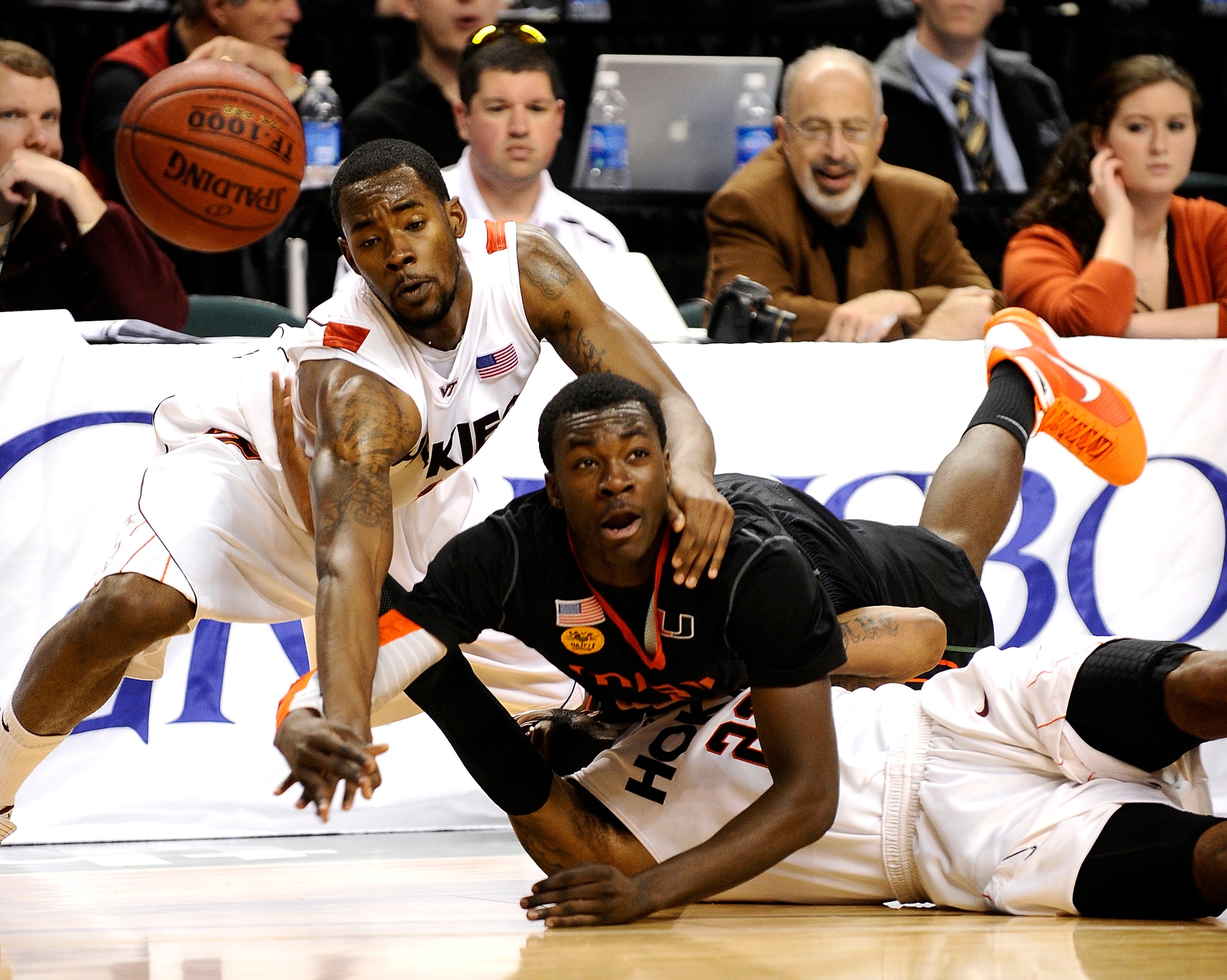 GREENSBORO, NC - MARCH 12:  Malcolm Delaney #23 and Terrell Bell #1 of the Virginia Tech Hokies fights for a loose ball with Durand Scott #1  of the University of Miami Hurricanes in their quarterfinal game in the 2010 ACC Men's Basketball Tournament at t