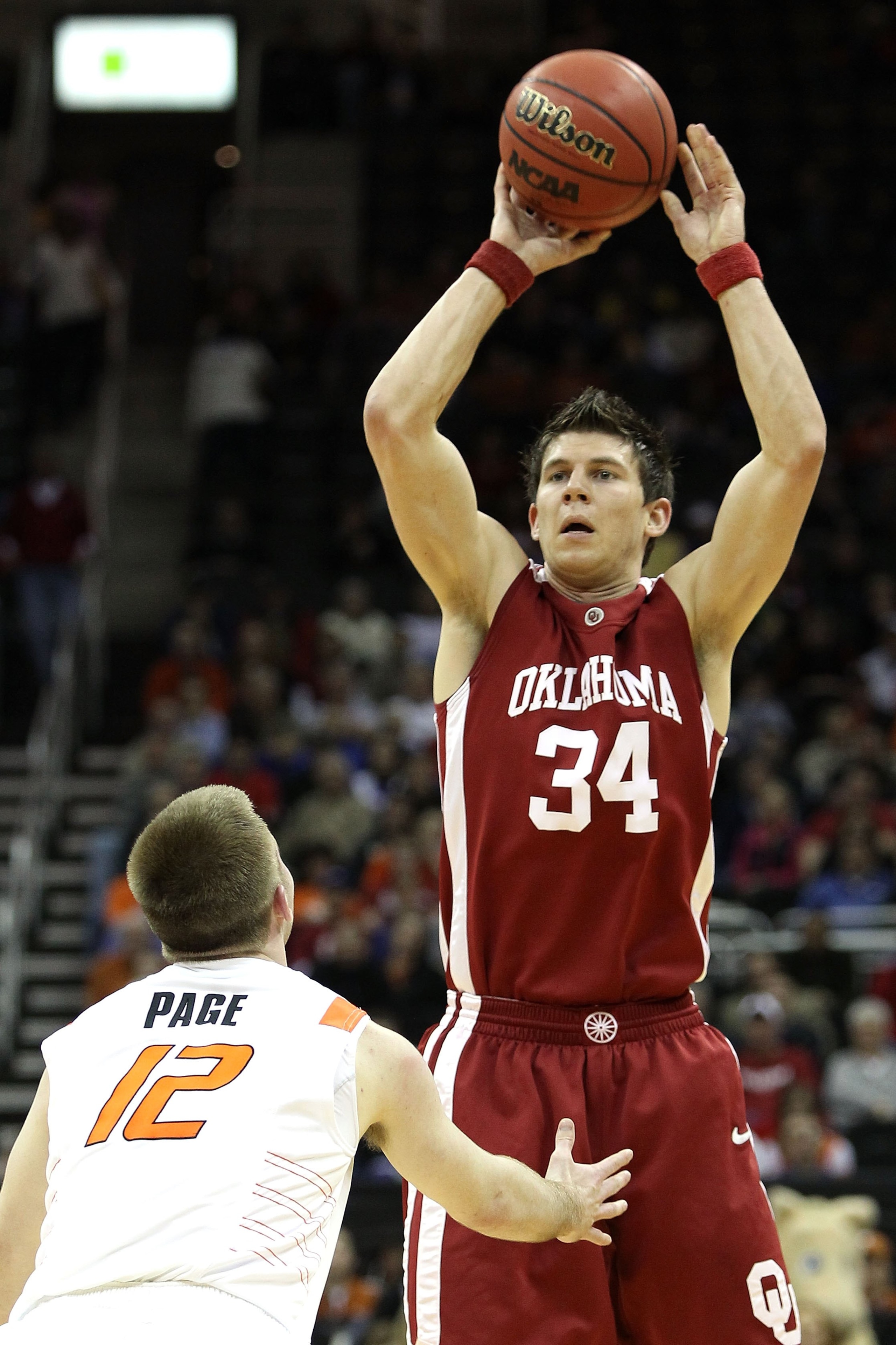 KANSAS CITY, MO - MARCH 10:  Cade Davis #34 of the Oklahoma Sooners moves the ball as he is covered by Keiton Page #12 of the Oklahoma State Cowboys during the first round game of the 2010 Phillips 66 Big 12 Men's Basketball Tournament at the Sprint Cente
