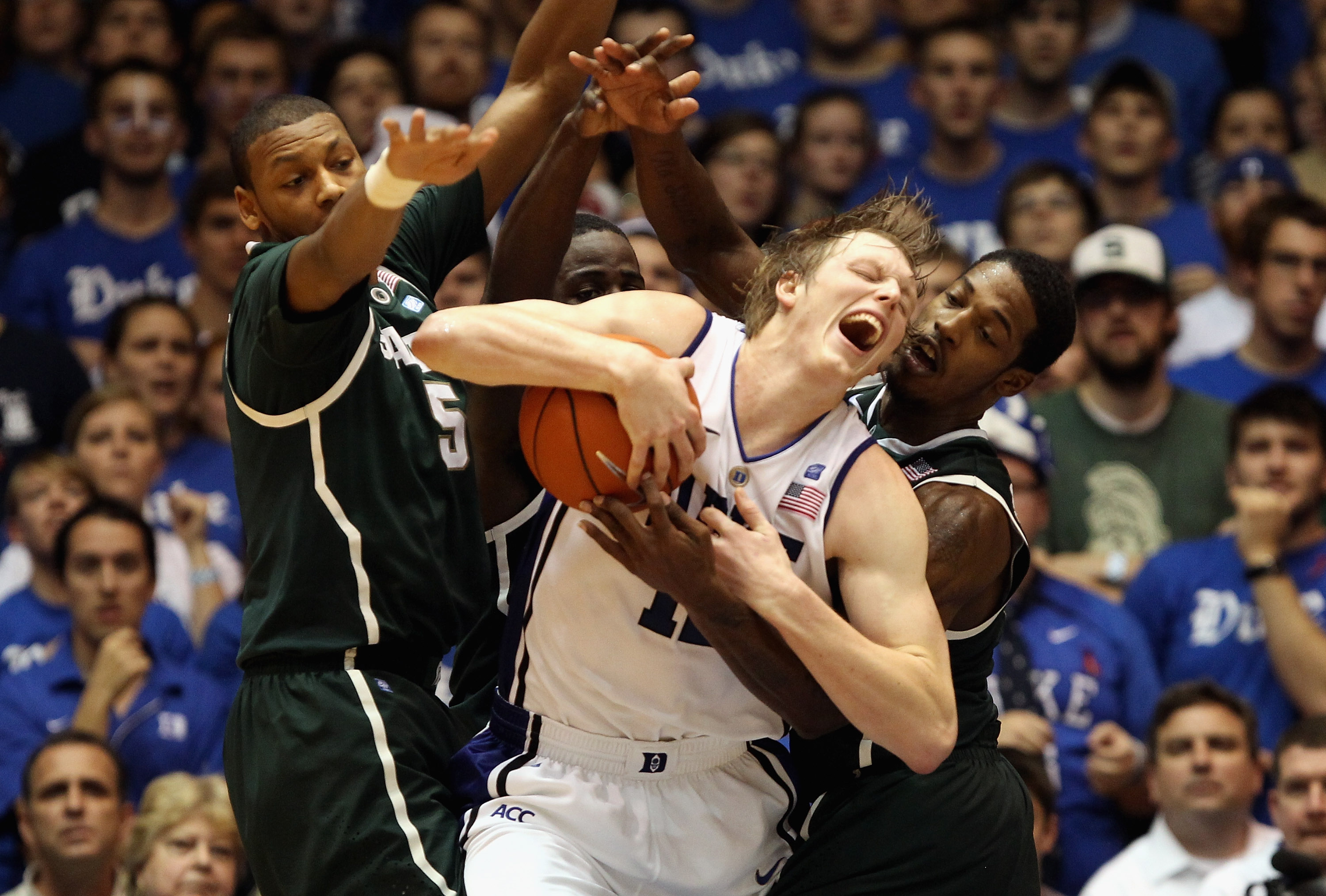 DURHAM, NC - DECEMBER 01: Teammates Adreian Payne #5 and Durrell Summers #15 of the Michigan State Spartans foul Kyle Singler #12 of the Duke Blue Devils during their game at Cameron Indoor Stadium on December 1, 2010 in Durham, North Carolina. (Photo by