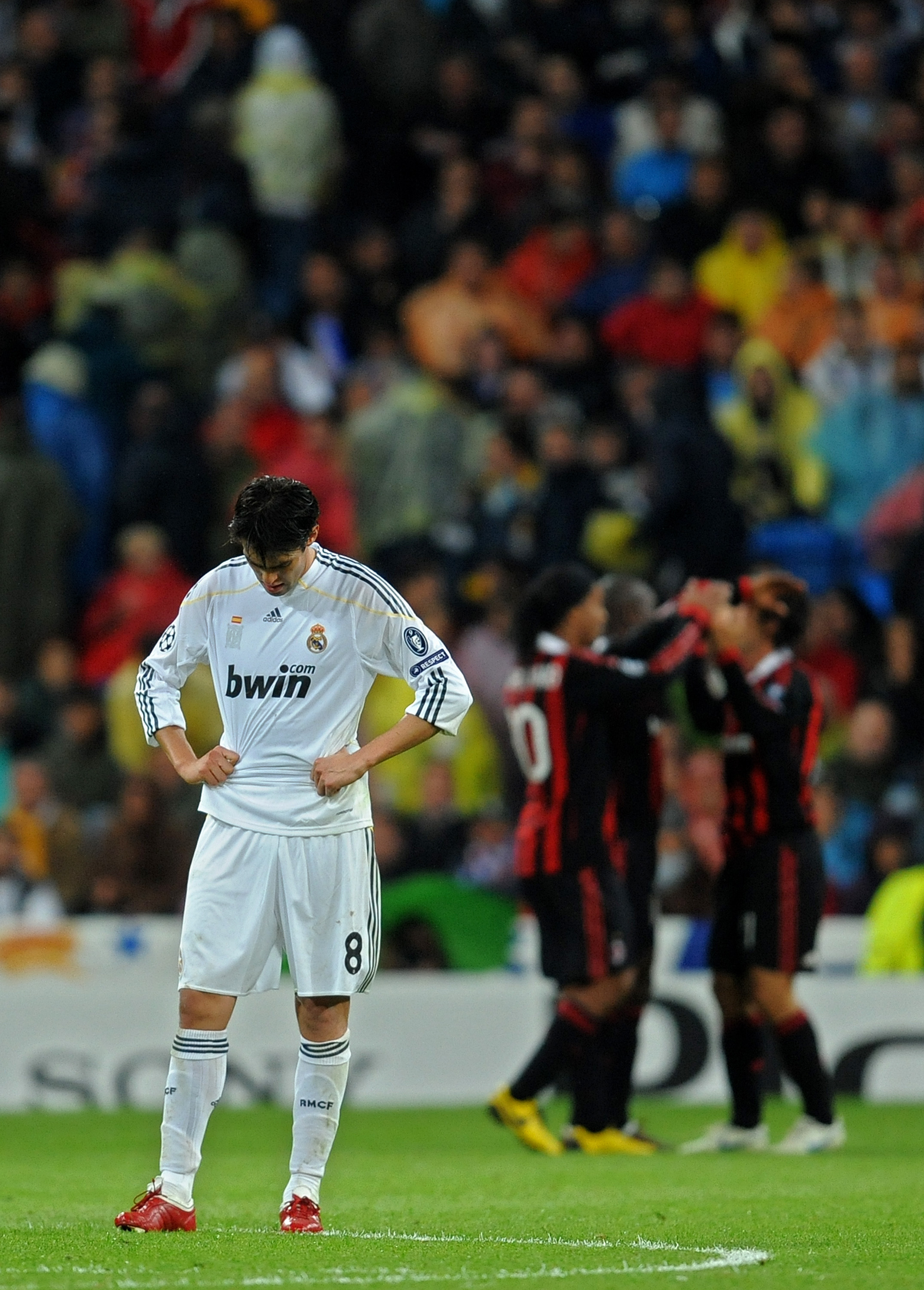 MADRID, SPAIN - OCTOBER 21:  Kaka (L) of Real Madrid stands dejected after conceding a goal as AC Milan players celebrate in the background during the Champions League group C match between Real Madrid and AC Milan at the Estadio Santiago Bernabeu on Octo