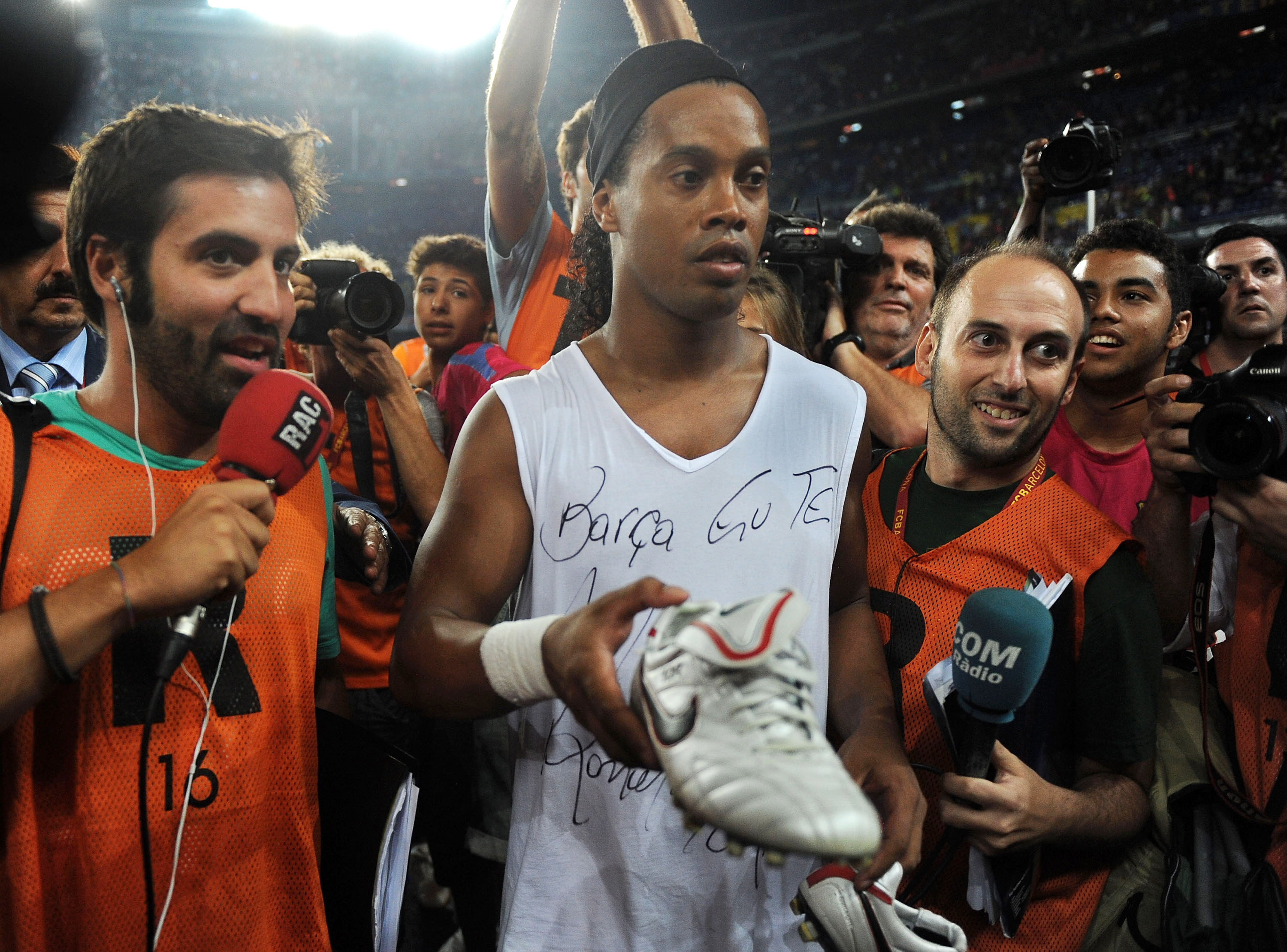 BARCELONA, SPAIN - AUGUST 25:  Ronaldinho of AC Milan and formerly of Barcelona gives away his boots to a fan at the Joan Gamper Trophy match between Barcelona and AC Milan at Camp Nou stadium on August 25, 2010 in Barcelona, Spain.  (Photo by Denis Doyle