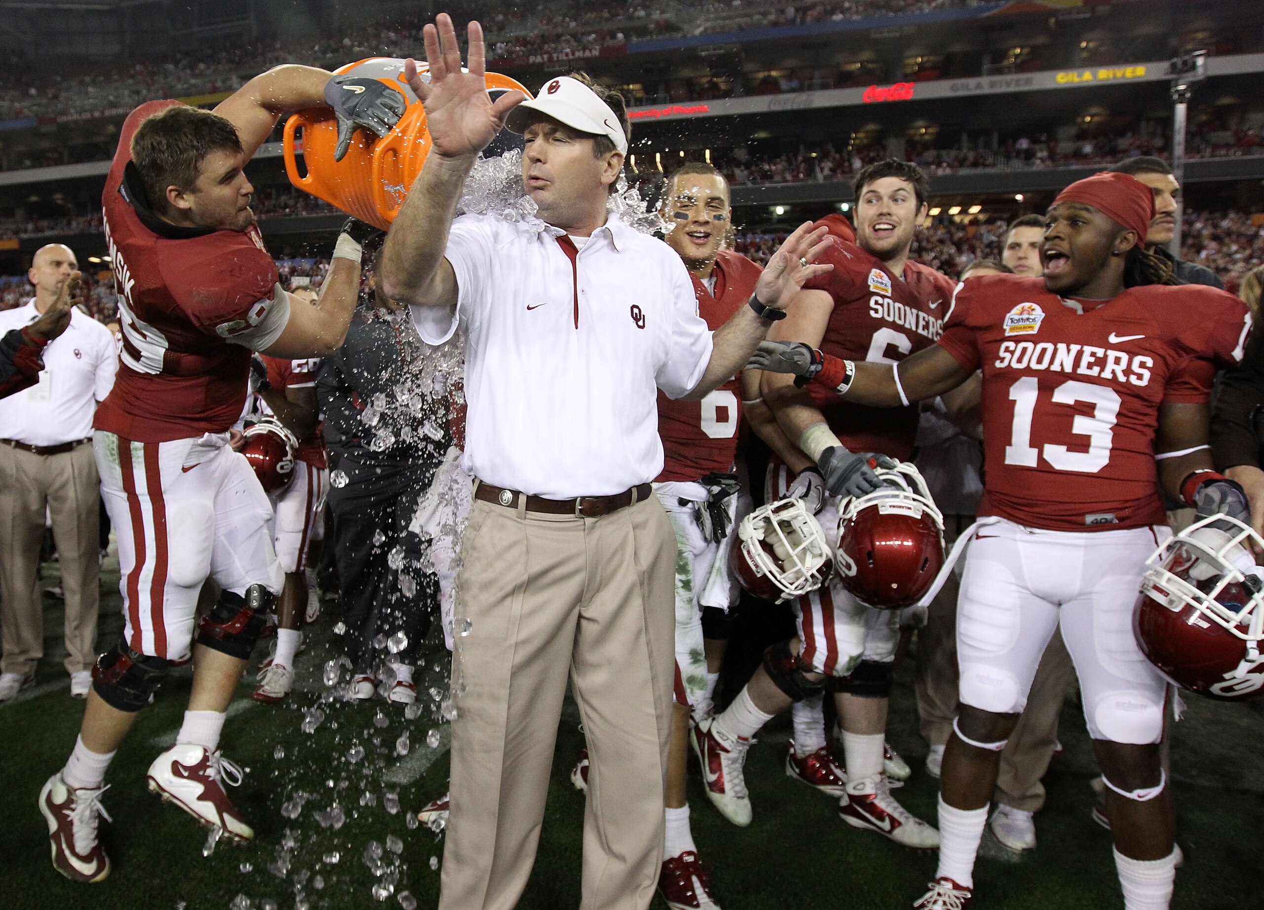 GLENDALE, AZ - JANUARY 01:  Head coach Bob Stoops has a Gatorade bucket dumped on him by Eric Mensik #69 late in the fourth quarter before the Sooners 48-20 victory against the Connecticut Huskies during the Tostitos Fiesta Bowl at the Universtity of Phoe
