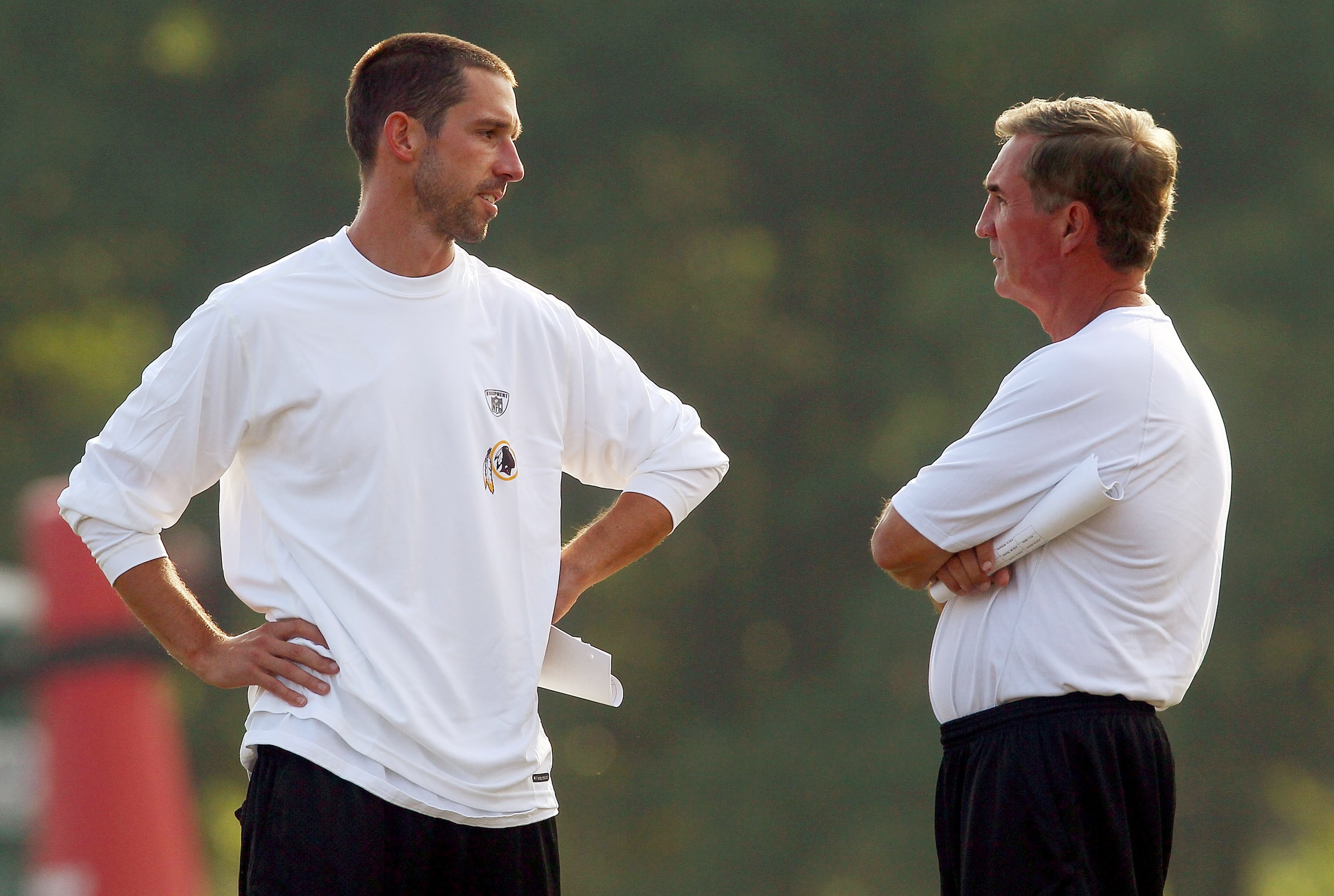 ASHBURN, VA - AUGUST 06:  Head Coach Mike Shanahan (R) of the Washington Redskins talks with his son Kyle Shanahan (L) offensive coordinator for the team during Redskins training camp on August 6, 2010 in Ashburn, Virginia.  (Photo by Win McNamee/Getty Im