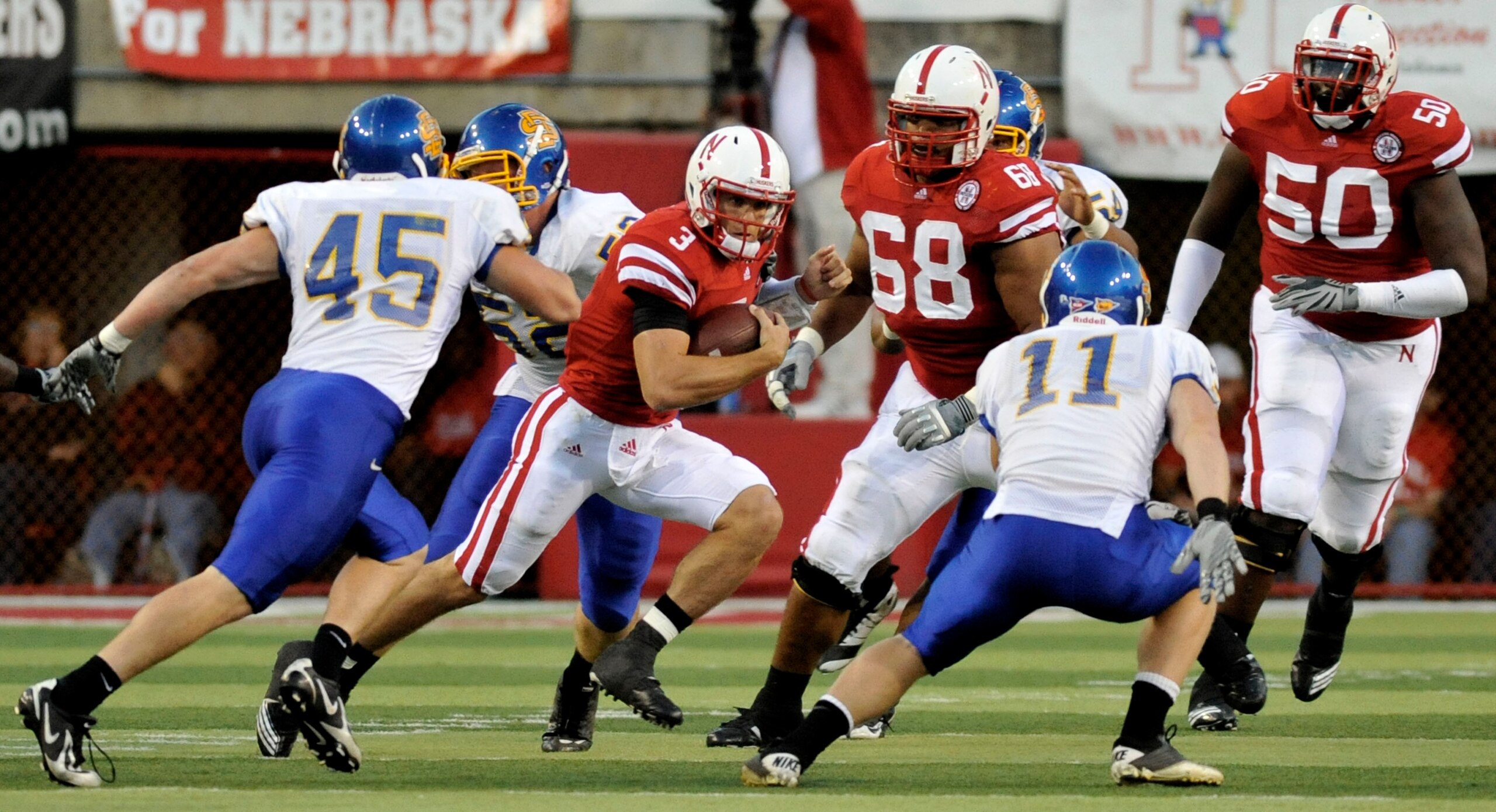 LINCOLN, NE - SEPTEMBER 25: !Quarterback Taylor Martinez #3 of the Nebraska Cornhuskers tries to elude linebacker Michael Lien #45 and linebacker Erich Feller #11of the South Dakota State Jackrabbits during first half action of their game at Memorial Stad