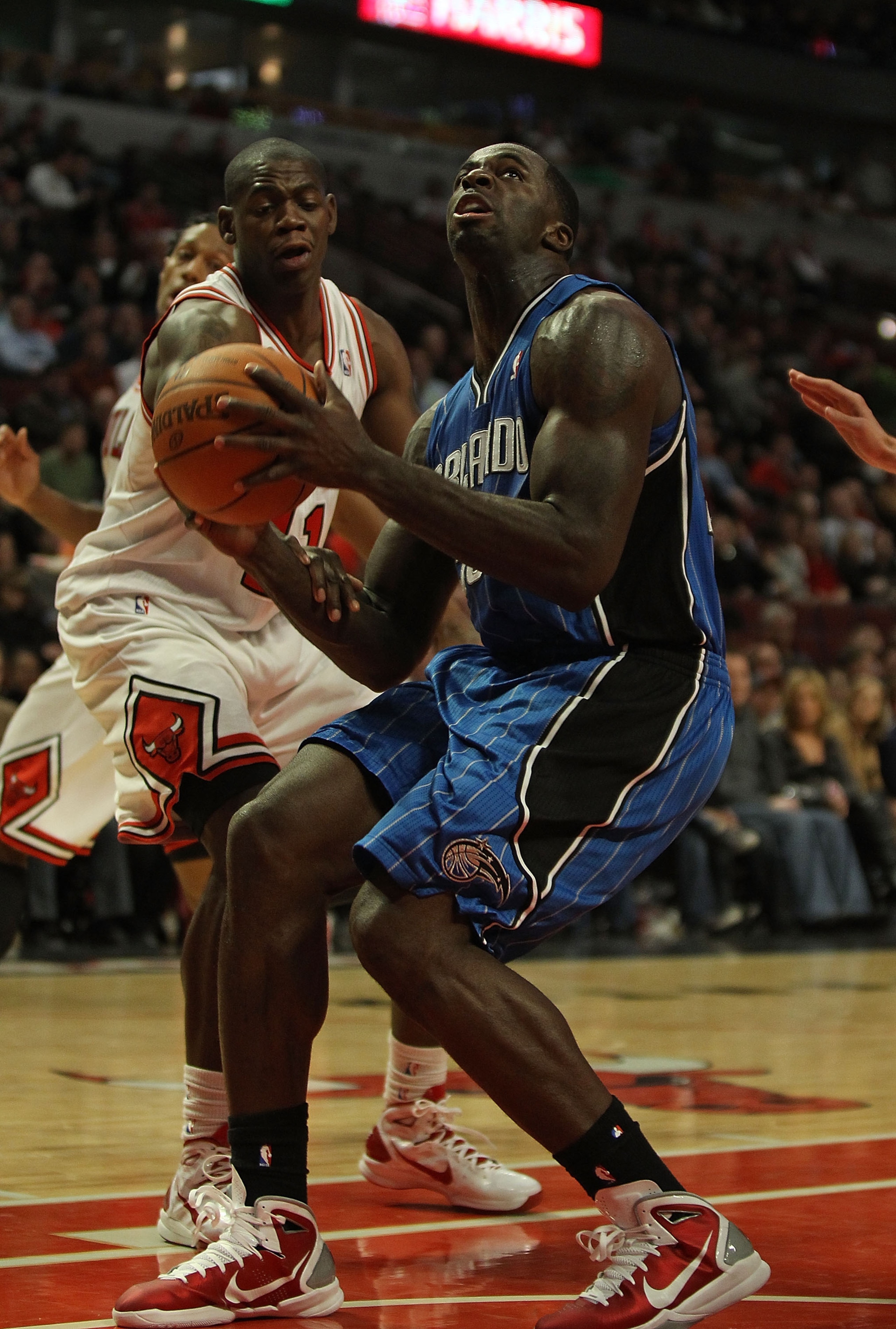 CHICAGO, IL - DECEMBER 01: Brandon Bass #30 of the Orlando Magic looks to shoot under pressure from Ronnie Brewer #11 of the Chicago Bulls at the United Center on December 1, 2010 in Chicago, Illinois. The Magic defeated the Bulls 107-78. NOTE TO USER: Us