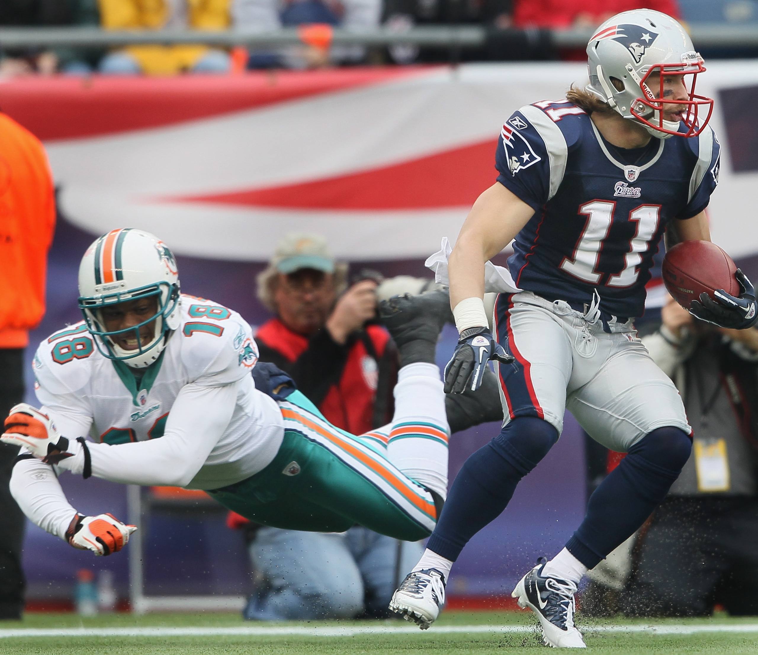 FOXBORO, MA - JANUARY 02: Julian Edleman #11 of the New England Patriots avoids Roberto Wallace #18 of the Miami Dolphins on January 2, 2011 at Gillette Stadium in Foxboro, Massachusetts. (Photo by Elsa/Getty Images) FOXBORO, MA - JANUARY 02: Julian Edleman #11 of the New England Patriots avoids Roberto Wallace #18 of the Miami Dolphins on January 2, 2011 at Gillette Stadium in Foxboro, Massachusetts. (Photo by Elsa/Getty Images)
