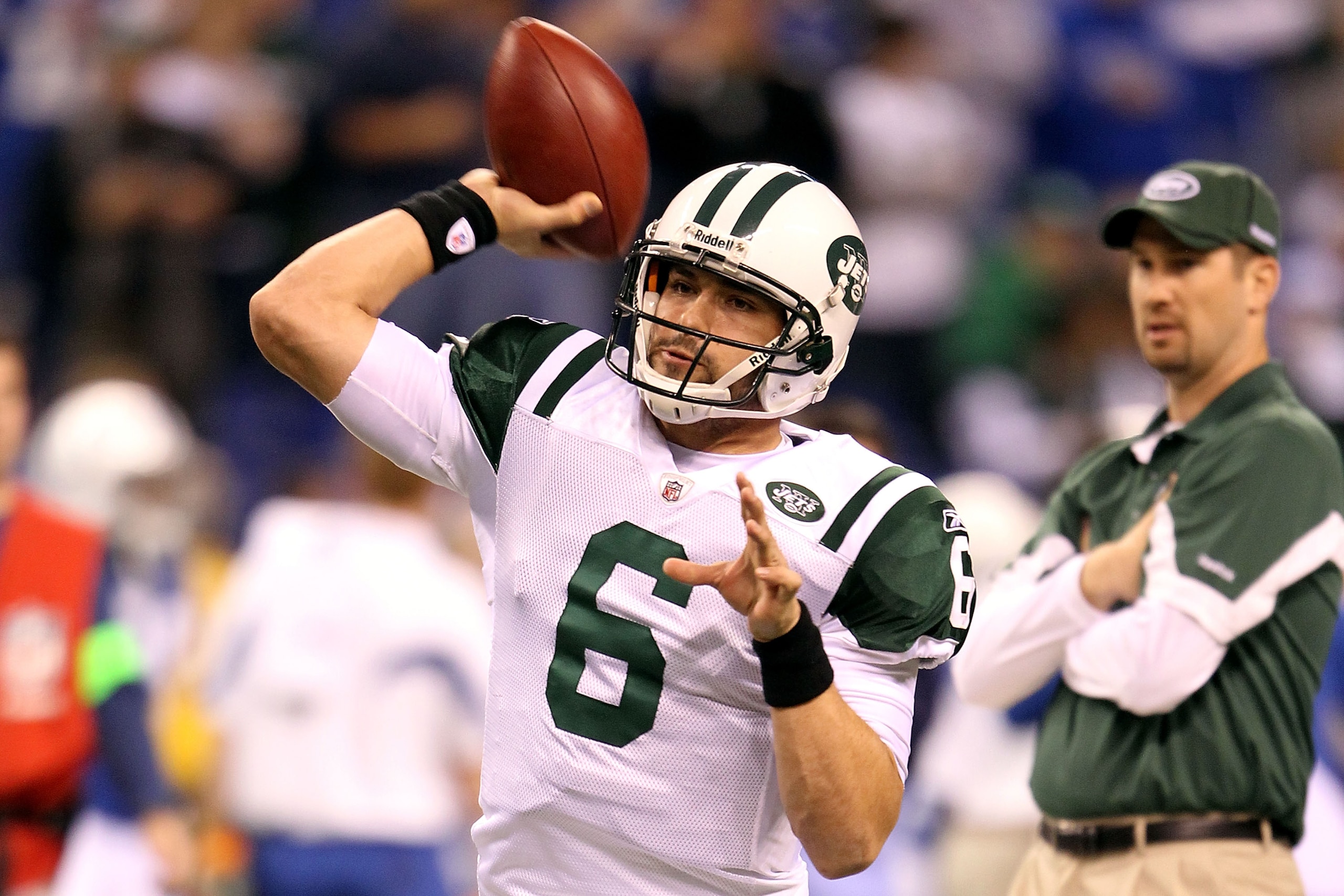 INDIANAPOLIS, IN - JANUARY 08:  Quarterback Mark Sanchez #6 of the New York Jets warms up as offensive coordinator Brian Schottenheimer looks on against the Indianapolis Colts during their 2011 AFC wild card playoff game at Lucas Oil Stadium on January 8,