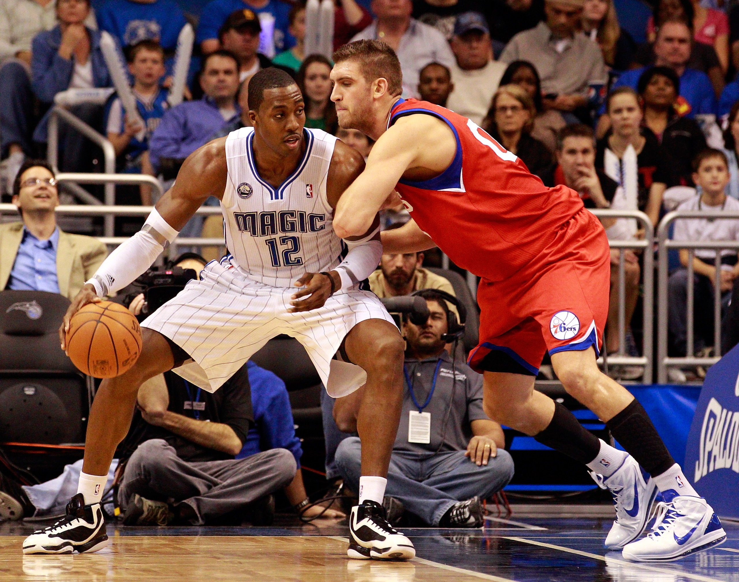 ORLANDO, FL - DECEMBER 18:  Spencer Hawes #00 of the Philadelphia 76ers guards Dwight Hoawrd #12 of the Orlando Magic during the game at Amway Arena on December 18, 2010 in Orlando, Florida.  NOTE TO USER: User expressly acknowledges and agrees that, by d