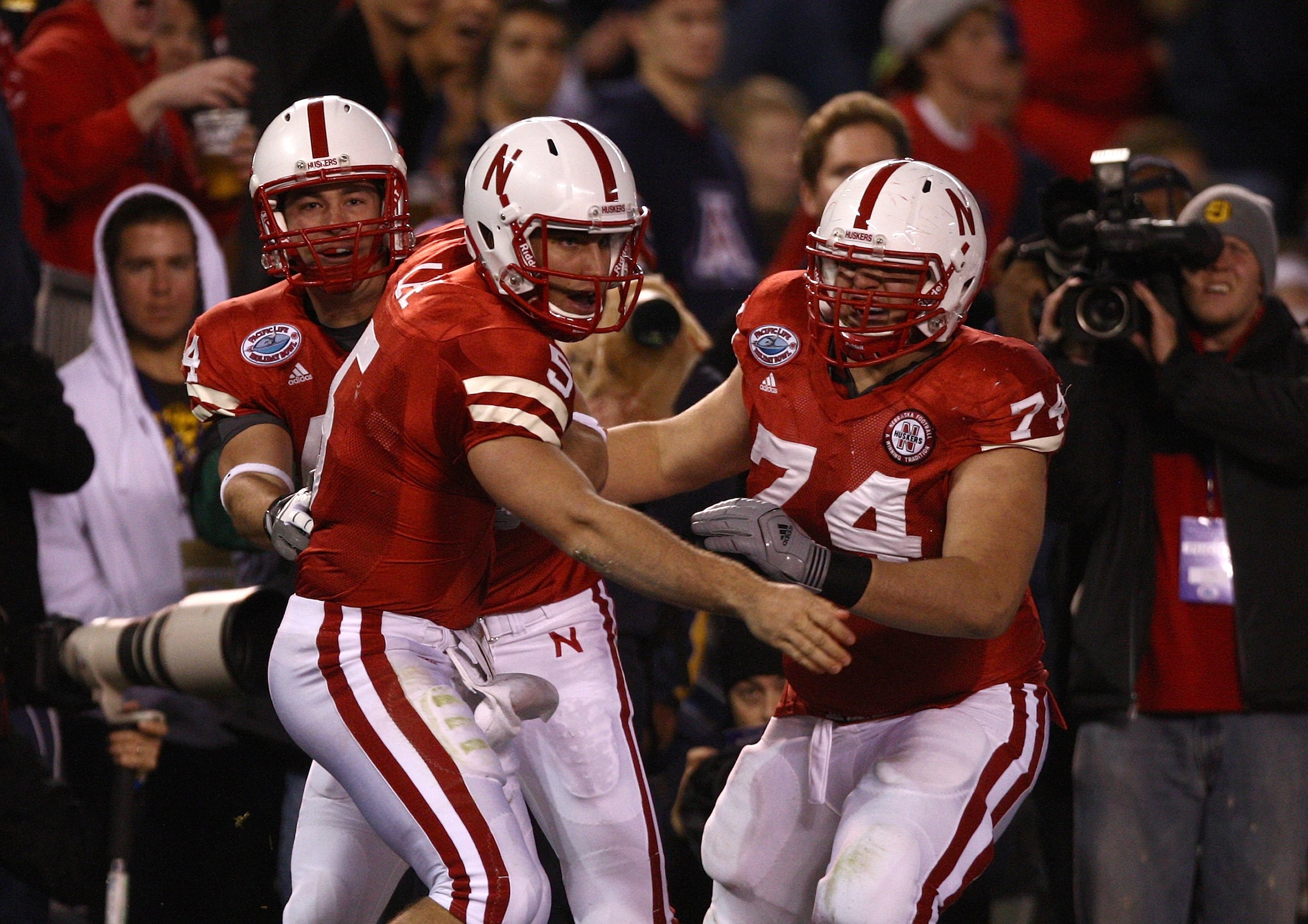 SAN DIEGO - DECEMBER 30: Quarterback Zac Lee #5 of the University of Nebraska Cornhuskers is mobbed by teammates after scoring the first touchdown against the University of Arizona Wildcats during the Pacific Life Holiday Bowl on December 30, 2009 at Qua SAN DIEGO - DECEMBER 30: Quarterback Zac Lee #5 of the University of Nebraska Cornhuskers is mobbed by teammates after scoring the first touchdown against the University of Arizona Wildcats during the Pacific Life Holiday Bowl on December 30, 2009 at Qua
