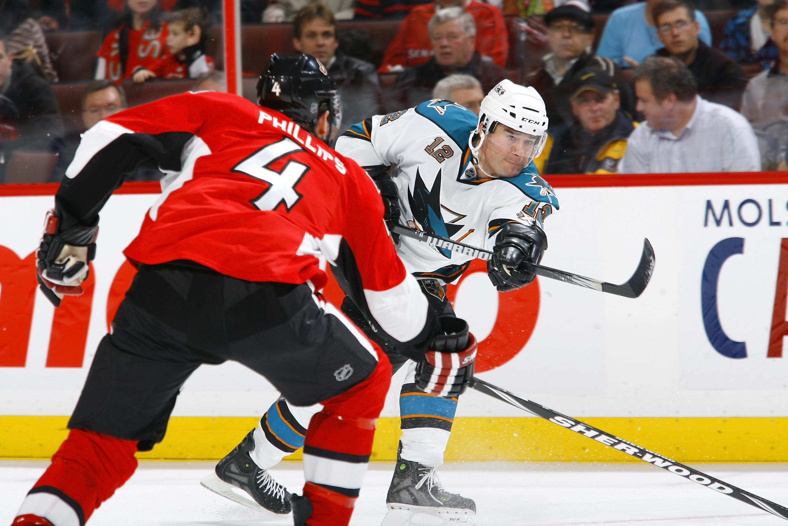 OTTAWA, ON - DECEMBER 02:  Patrick Marleau #12 of the San Jose Sharks fires a slapshot past defender Chris Phillips #4 of the Ottawa Senators in a game at Scotiabank Place on December 2, 2010 in Ottawa, Ontario, Canada.  (Photo by Phillip MacCallum/Getty