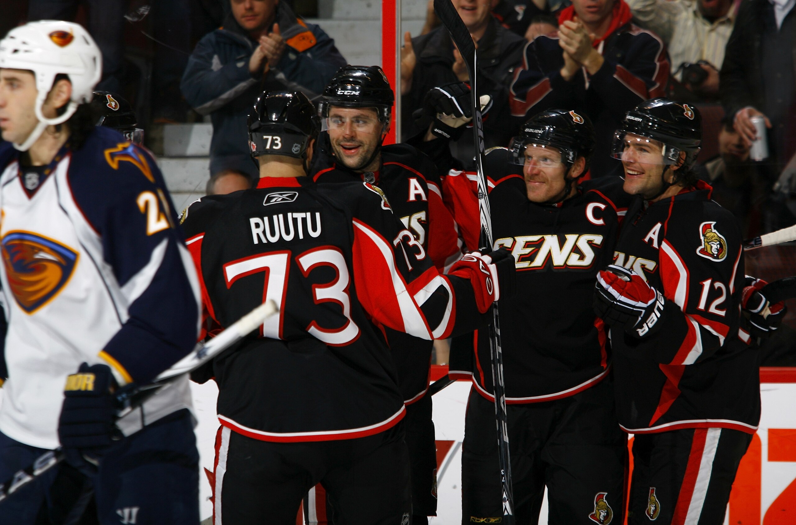 OTTAWA, ON - DECEMBER 13:  Daniel Alfredsson #11 of the Ottawa Senators celebrates his goal with teammates Jarkko Ruutu #73;Chris Phillips #4 and Mike Fisher #12 while Chris Thornburn #27 of the Atlanta Thrashers skates away dejectedly in a game at Scotia