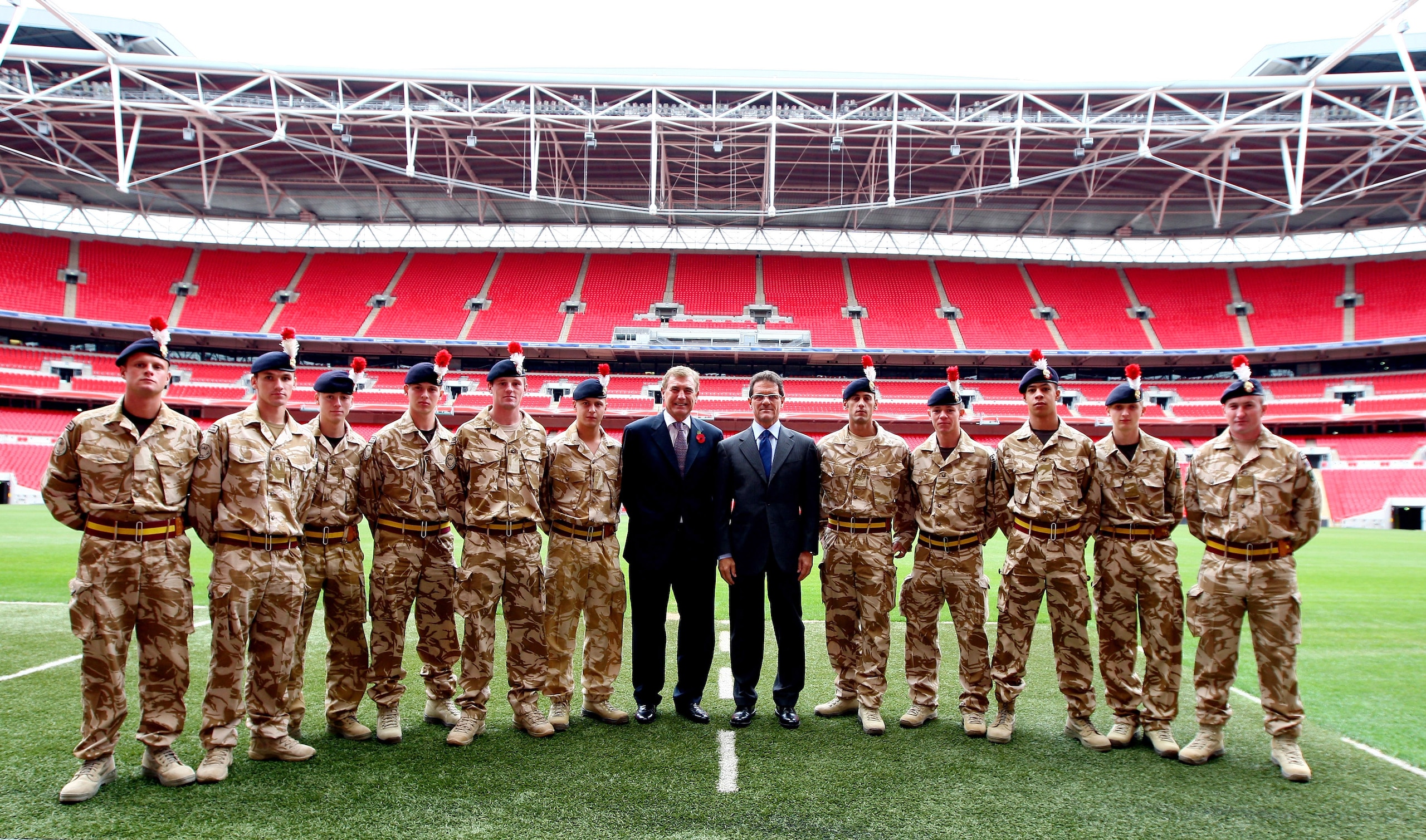 LONDON, ENGLAND - NOVEMBER 06: England Manager Fabio Capello and Sir Trevor Brooking pose with members of The Royal Regiment Second Fusiliers before the official unveiling of the sculpture of Sir Alf Ramsey at Wembley Stadium on November 6, 2009 in Londo LONDON, ENGLAND - NOVEMBER 06: England Manager Fabio Capello and Sir Trevor Brooking pose with members of The Royal Regiment Second Fusiliers before the official unveiling of the sculpture of Sir Alf Ramsey at Wembley Stadium on November 6, 2009 in Londo