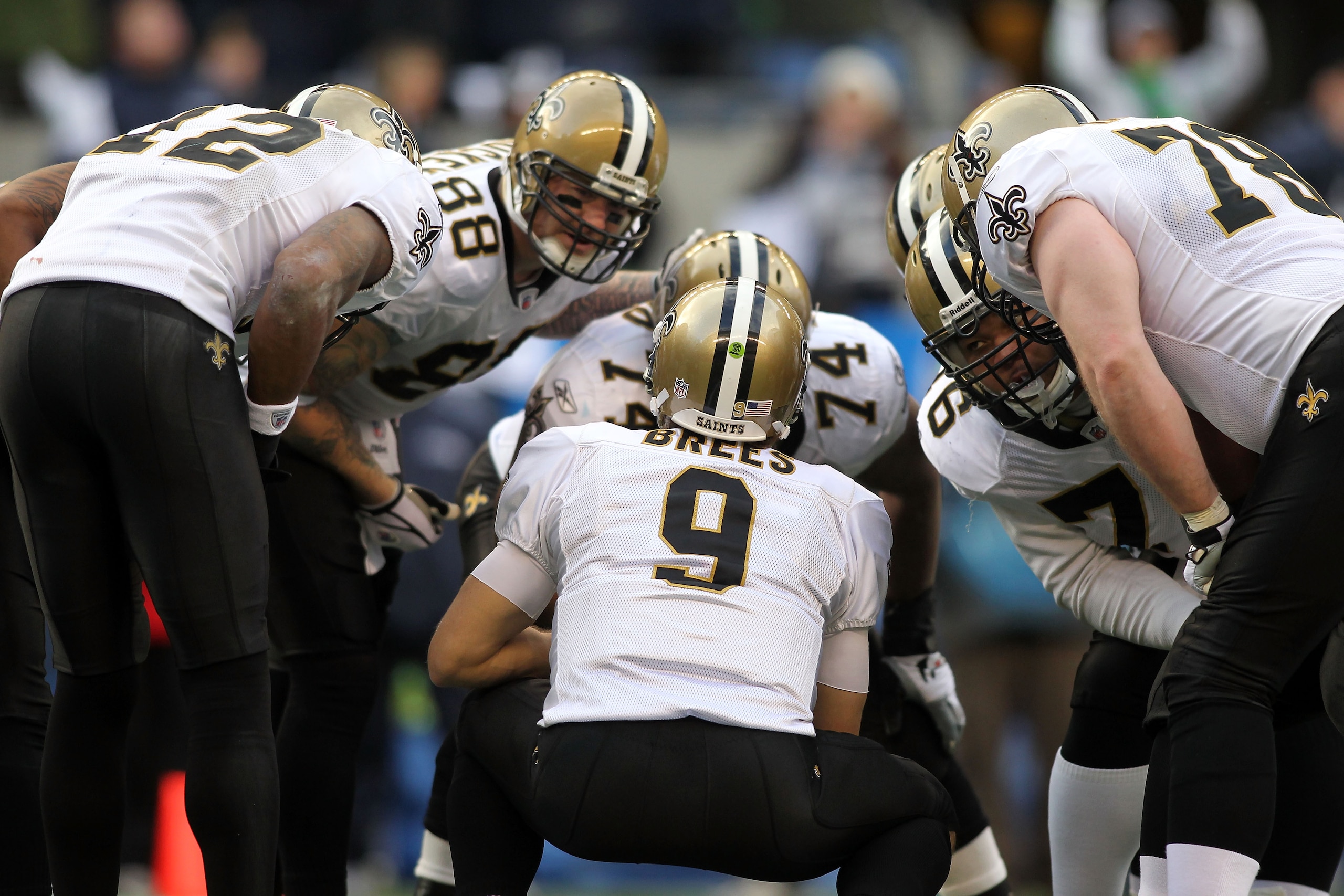 SEATTLE, WA - JANUARY 08:  Quarterback Drew Brees #9 of the New Orleans Saints kneels down in the huddle in the second quarter against the Seattle Seahawks during the 2011 NFC wild-card playoff game at Qwest Field on January 8, 2011 in Seattle, Washington