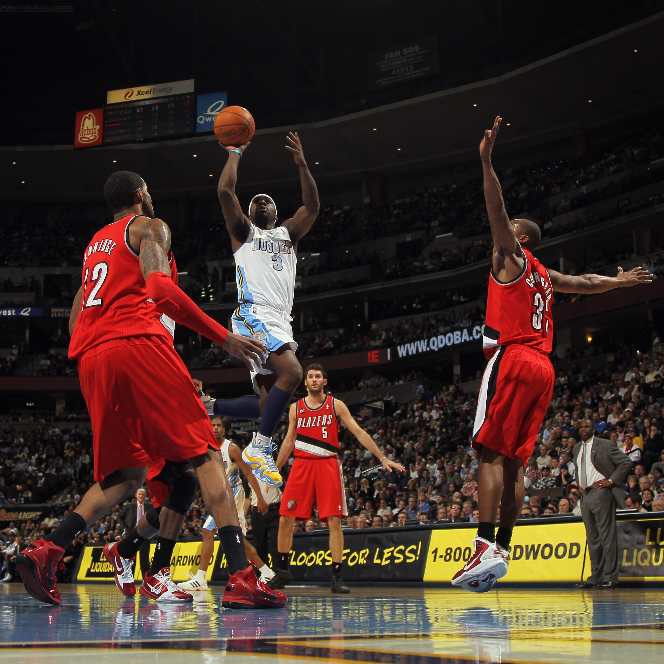 DENVER - DECEMBER 28:  Ty Lawson #3 of the Denver Nuggets takes a shot between Wesley Matthews #2 and Dante Cunningham #33 of the Portland Trail Blazers at Pepsi Center on December 28, 2010 in Denver, Colorado. The Nuggets defeated the Blazers 95-77. NOTE