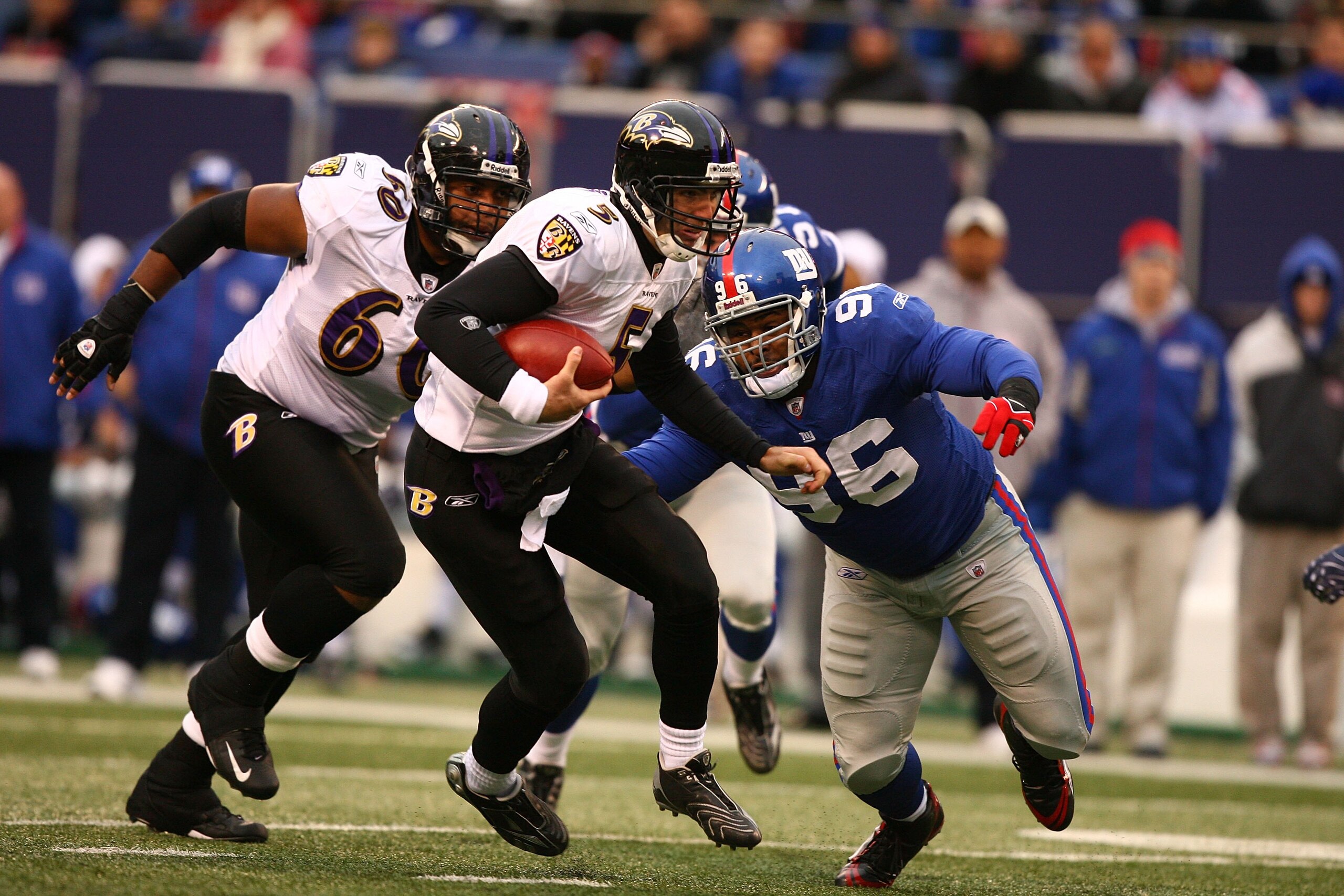 EAST RUTHERFORD, NJ - NOVEMBER 16:  Joe Flacco #5  of the Baltimore Ravens scrambles as Barry Cofield #96 of the New York Giants gives chase during their game on November 16, 2008 at Giants Stadium in East Rutherford, New Jersey.  (Photo by Al Bello/Getty