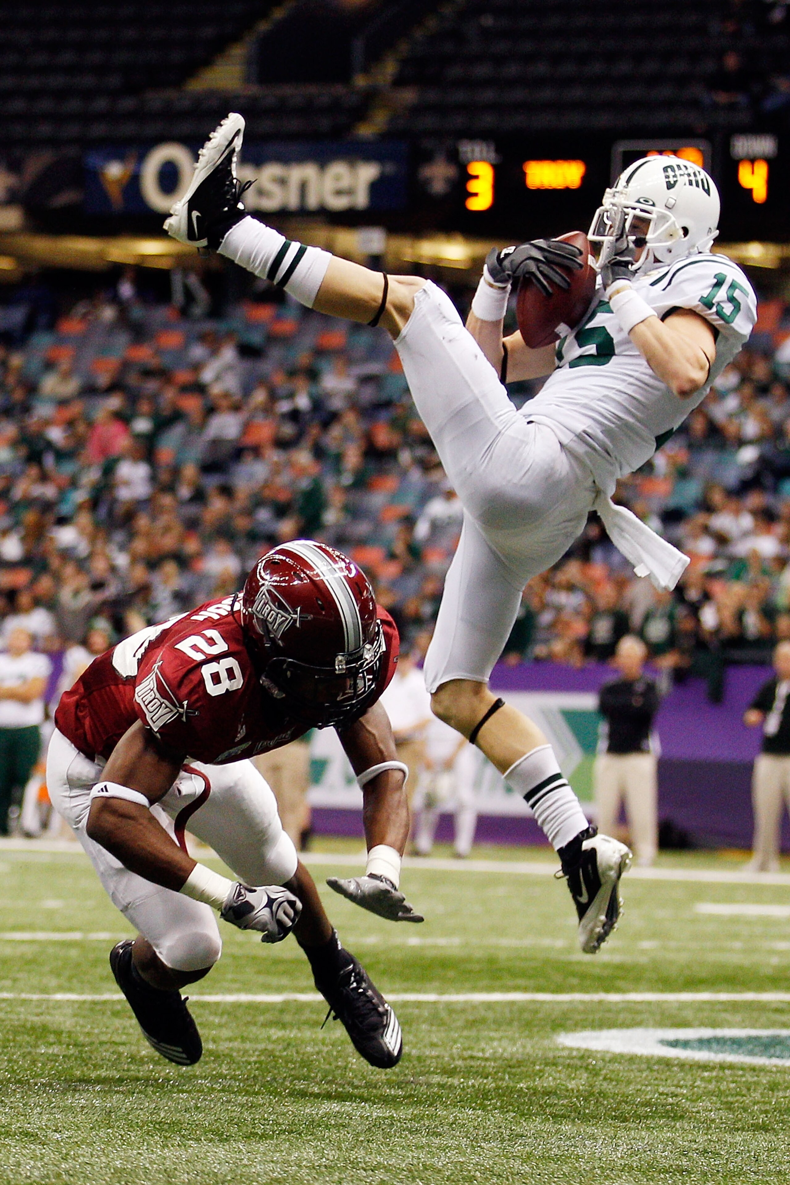 NEW ORLEANS, LA - DECEMBER 18:  Riley Dunlop #15 of the Ohio University Bobcats scores a touchdown over Cameron Hudson #28 of the Troy University Trojans  during the R&L Carriers New Orleans Bowl at the Louisiana Superdome on December 18, 2010 in New Orle