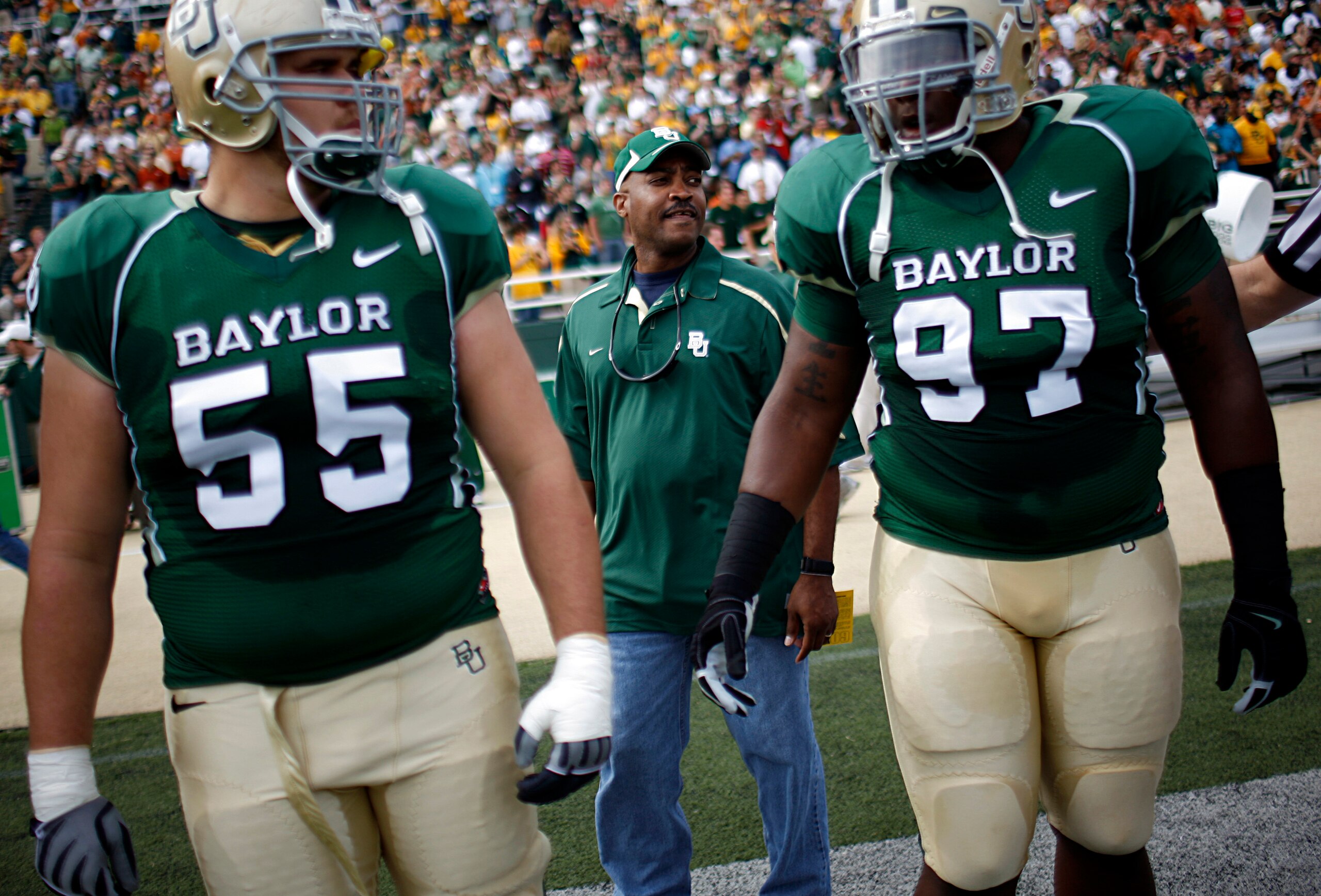 WACO, TX - NOVEMBER 14:  Sgt. Mark Todd of the Fort Hood Police Department walks onto the field with center J.D. Walton #55 and nose tackle Trey Bryant #97 of the Baylor Bears to conduct the coin toss prior to the Texas Longhorns taking on the Baylor Bear