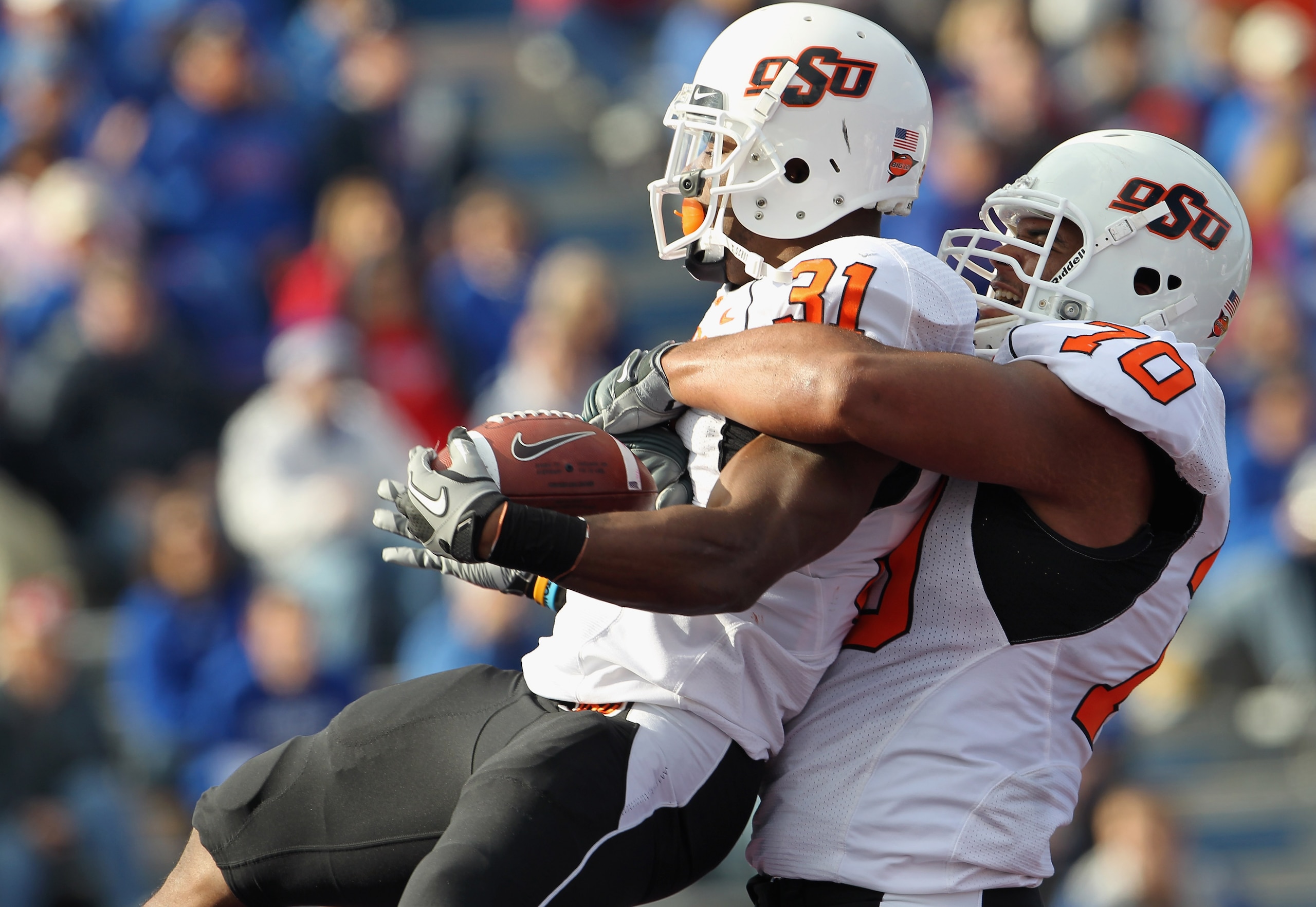 LAWRENCE, KS - NOVEMBER 20:  Jeremy Smith #31 of the Oklahoma State Cowboys is congratulated by Jonathan Rush #70 after a touchdown during the game against the Kansas Jayhawks on November 20, 2010 at Memorial Stadium in Lawrence, Kansas.  (Photo by Jamie 