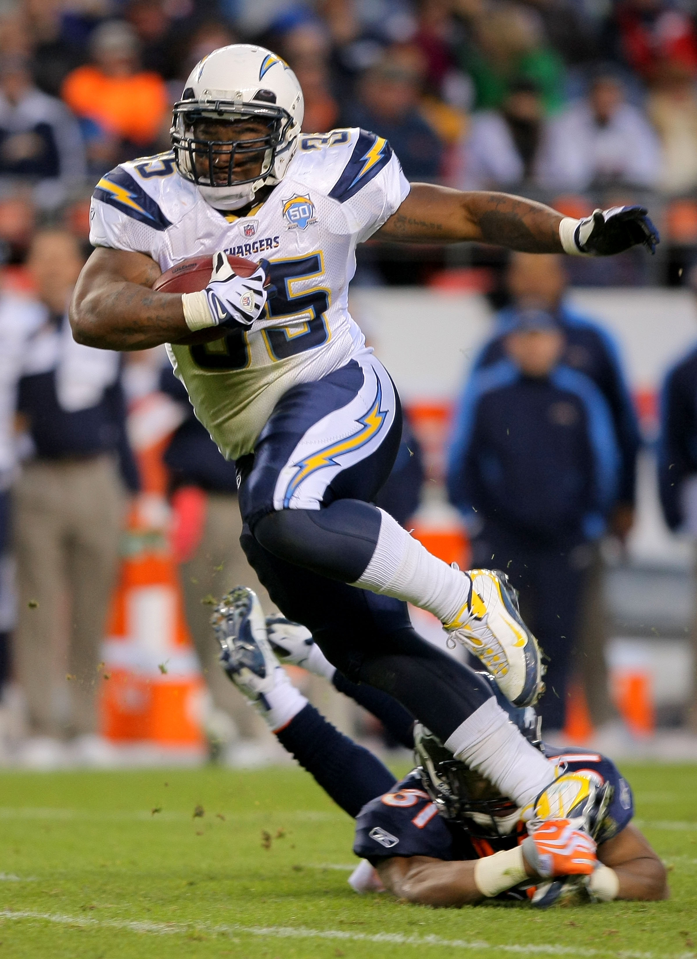 DENVER - NOVEMBER 22:  Mike Tolbert #35 of the San Diego Chargers eludes Darcel McBath #31 of the Denver Broncos as he rushes for a first down during NFL action at Invesco Field at Mile High on November 22, 2009 in Denver, Colorado. The Chargers defeated 
