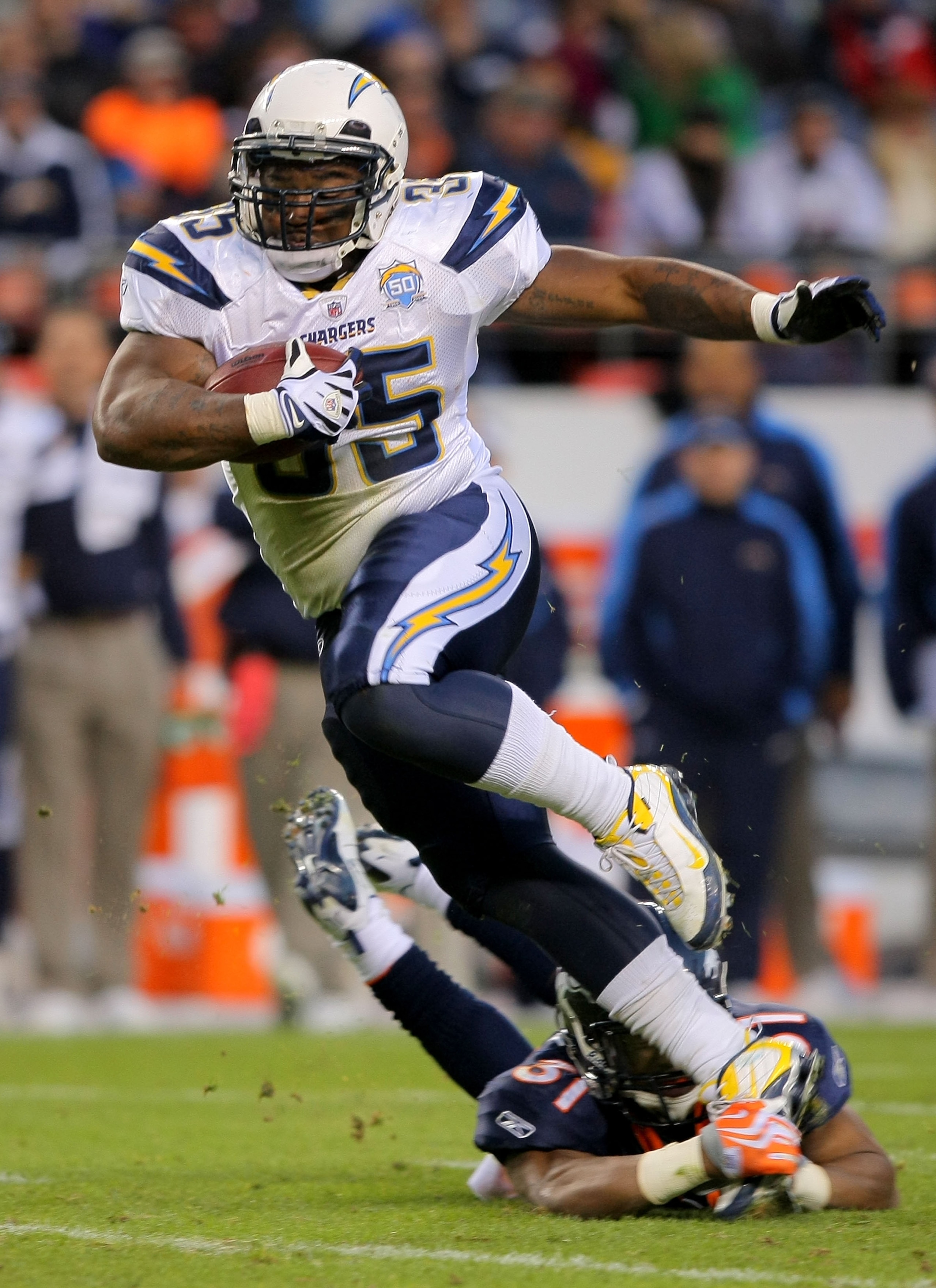 DENVER - NOVEMBER 22:  Mike Tolbert #35 of the San Diego Chargers eludes Darcel McBath #31 of the Denver Broncos as he rushes for a first down during NFL action at Invesco Field at Mile High on November 22, 2009 in Denver, Colorado. The Chargers defeated 