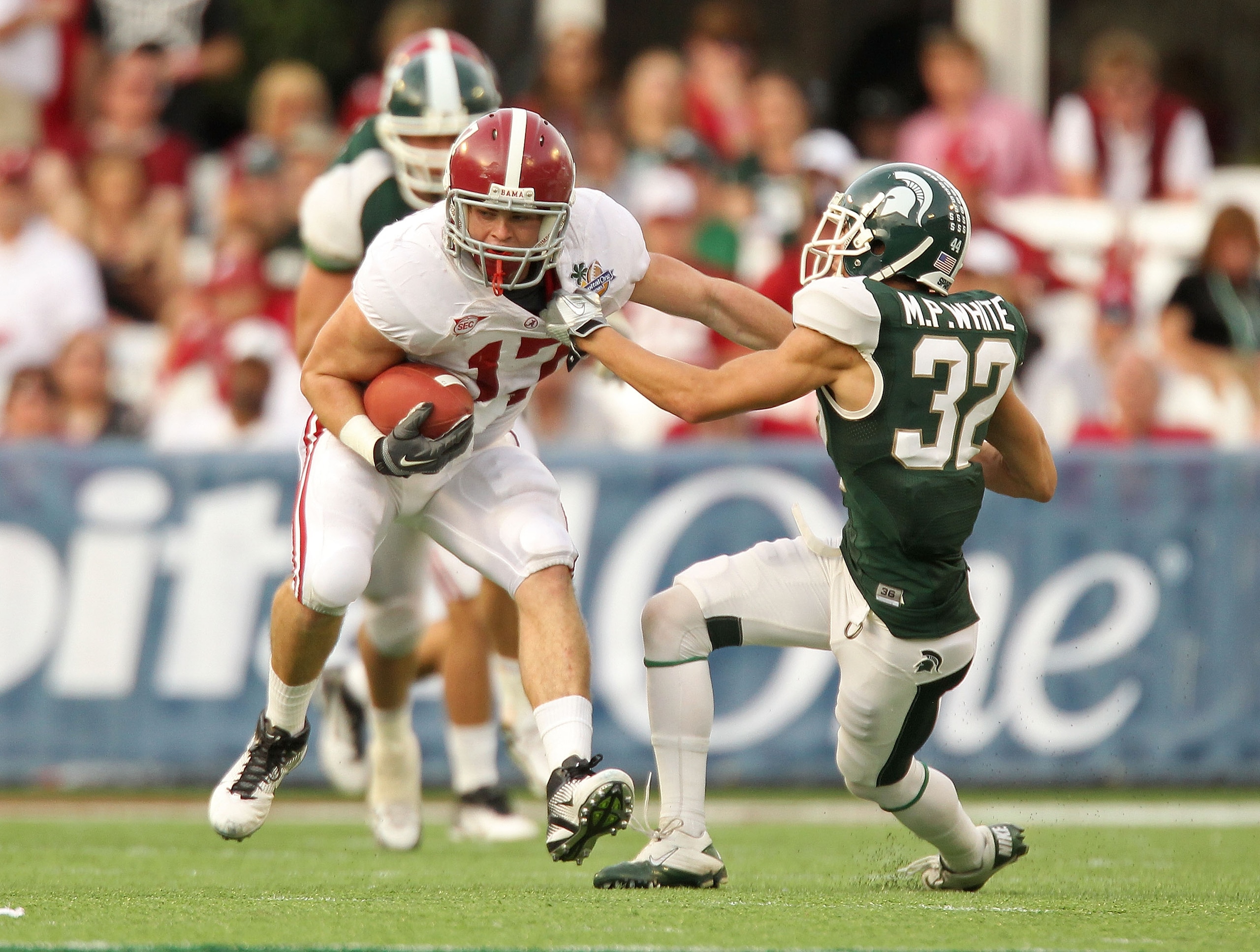 ORLANDO, FL - JANUARY 01:  Brad Smelley #17 of the Alabama Crimson Tide runs after a catch stiffarming Mitchell White #32 of the Michigan State Spartans during the Capitol One Bowl at the Florida Citrus Bowl on January 1, 2011 in Orlando, Florida.  (Photo
