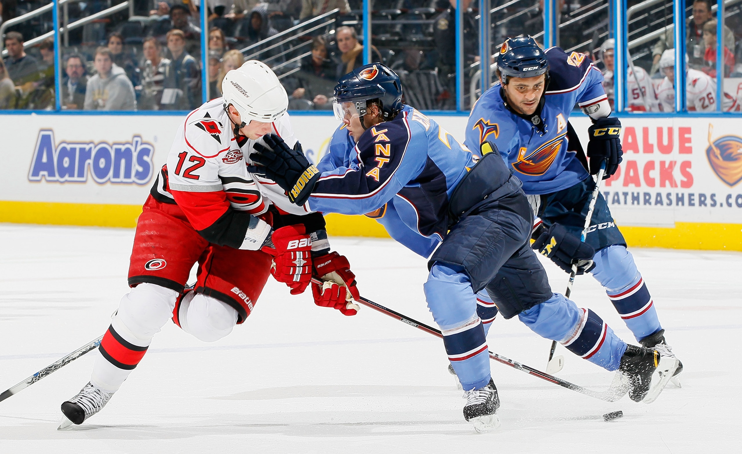ATLANTA, GA - DECEMBER 16:  Eric Staal #12 of the Carolina Hurricanes battles for the puck against Tobias Enstrom #39 and Dustin Byfuglien #33 of the Atlanta Thrashers at Philips Arena on December 16, 2010 in Atlanta, Georgia.  (Photo by Kevin C. Cox/Gett