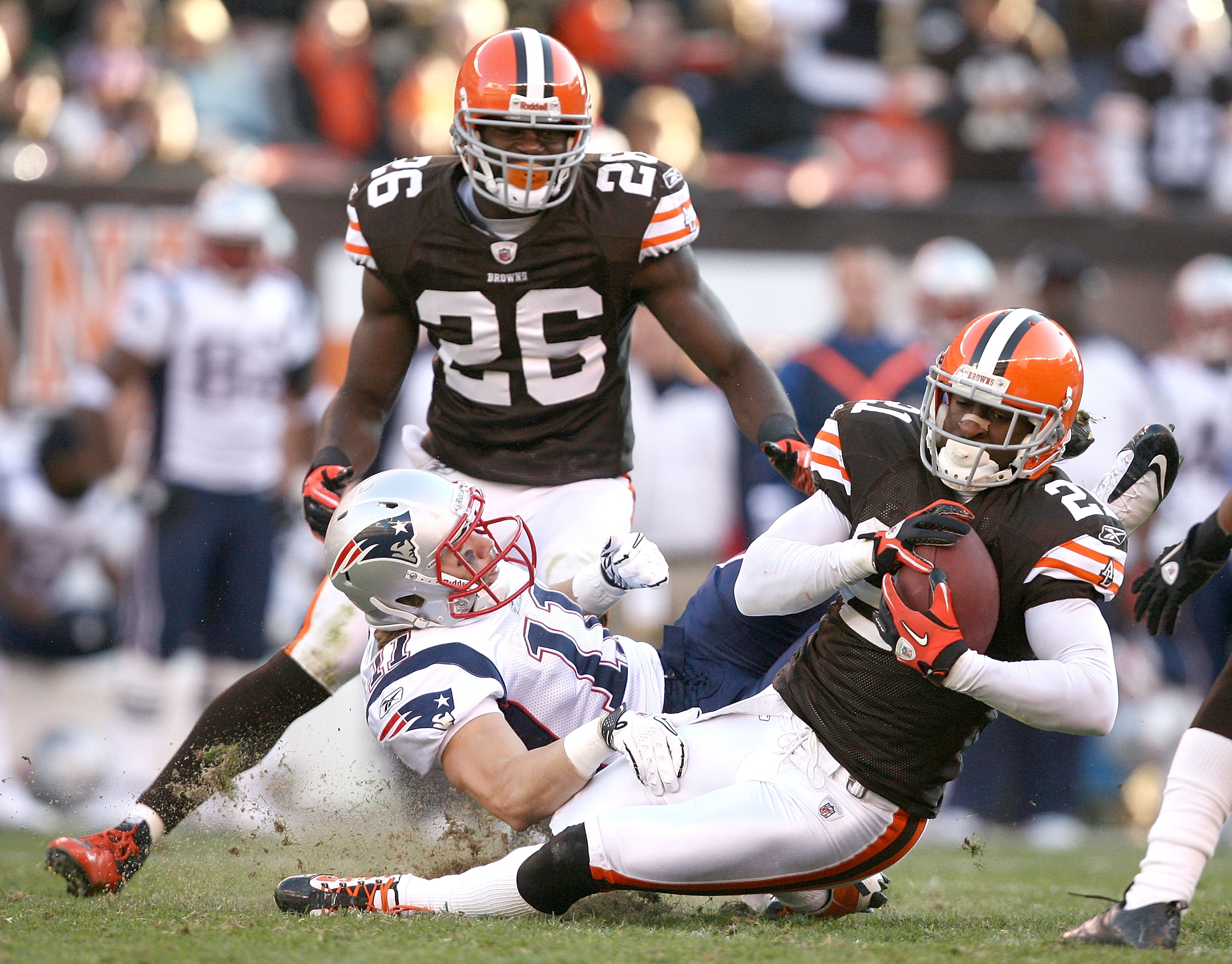 CLEVELAND - NOVEMBER 07:  Defensive back Abram Elam #26 of the Cleveland Browns watches as Eric Wright #21 intercepts the ball in front of wide receiver Julian Edelman #11 of the New England Patriots at Cleveland Browns Stadium on November 7, 2010 in Clev