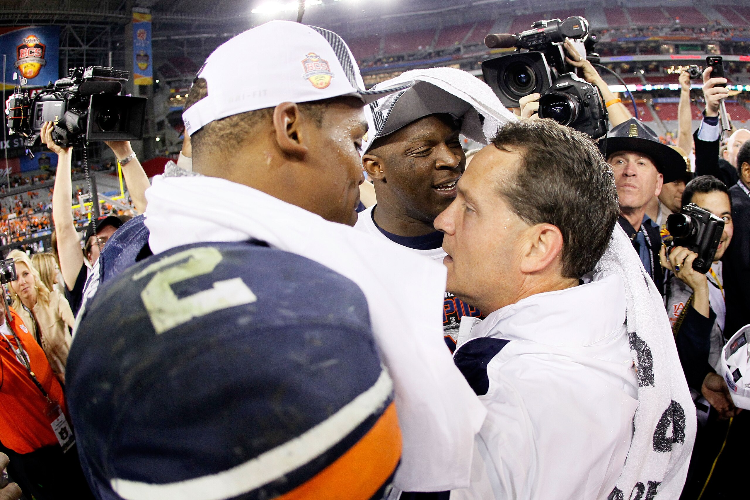 GLENDALE, AZ - JANUARY 10: Quarterback Cameron Newton #2 and head coach Gene Chizik of the Auburn Tigers celebrate the Tigers 22-19 victory with the fans after defeating the Oregon Ducks in the Tostitos BCS National Championship Game at University of Pho GLENDALE, AZ - JANUARY 10: Quarterback Cameron Newton #2 and head coach Gene Chizik of the Auburn Tigers celebrate the Tigers 22-19 victory with the fans after defeating the Oregon Ducks in the Tostitos BCS National Championship Game at University of Pho