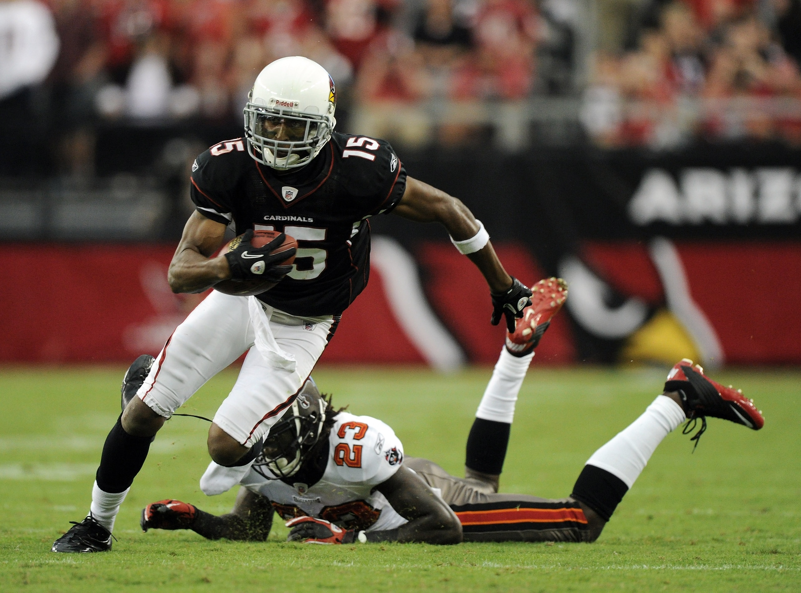 GLENDALE, AZ - OCTOBER 31:  Steve Breaston #15 of the Arizona Cardinals loses a shoe as he eludes the tackle from Myron Lewis #23 of the Tampa Bay Buccaneers during the fourth quarter at University of Phoenix Stadium on October 31, 2010 in Glendale, Arizo