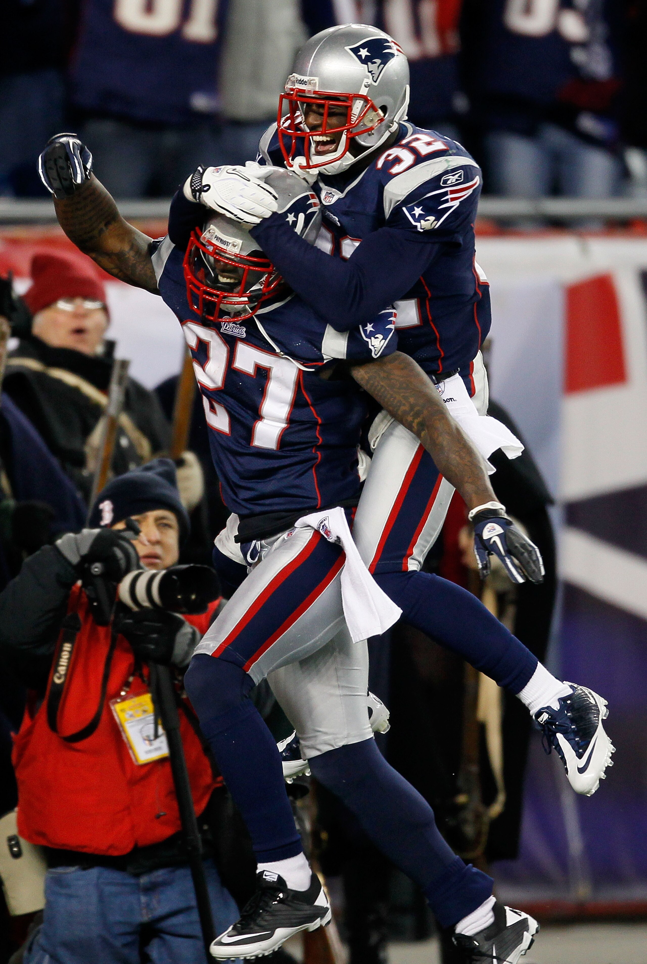 FOXBORO, MA - DECEMBER 19:  Cornerback Kyle Arrington #27 of the New England Patriots (R) is congratulated for scoring a touchdown after intercepting the ball and running 36 yards by teammate cornerback Devin McCourty #32 during the third quarter of the g