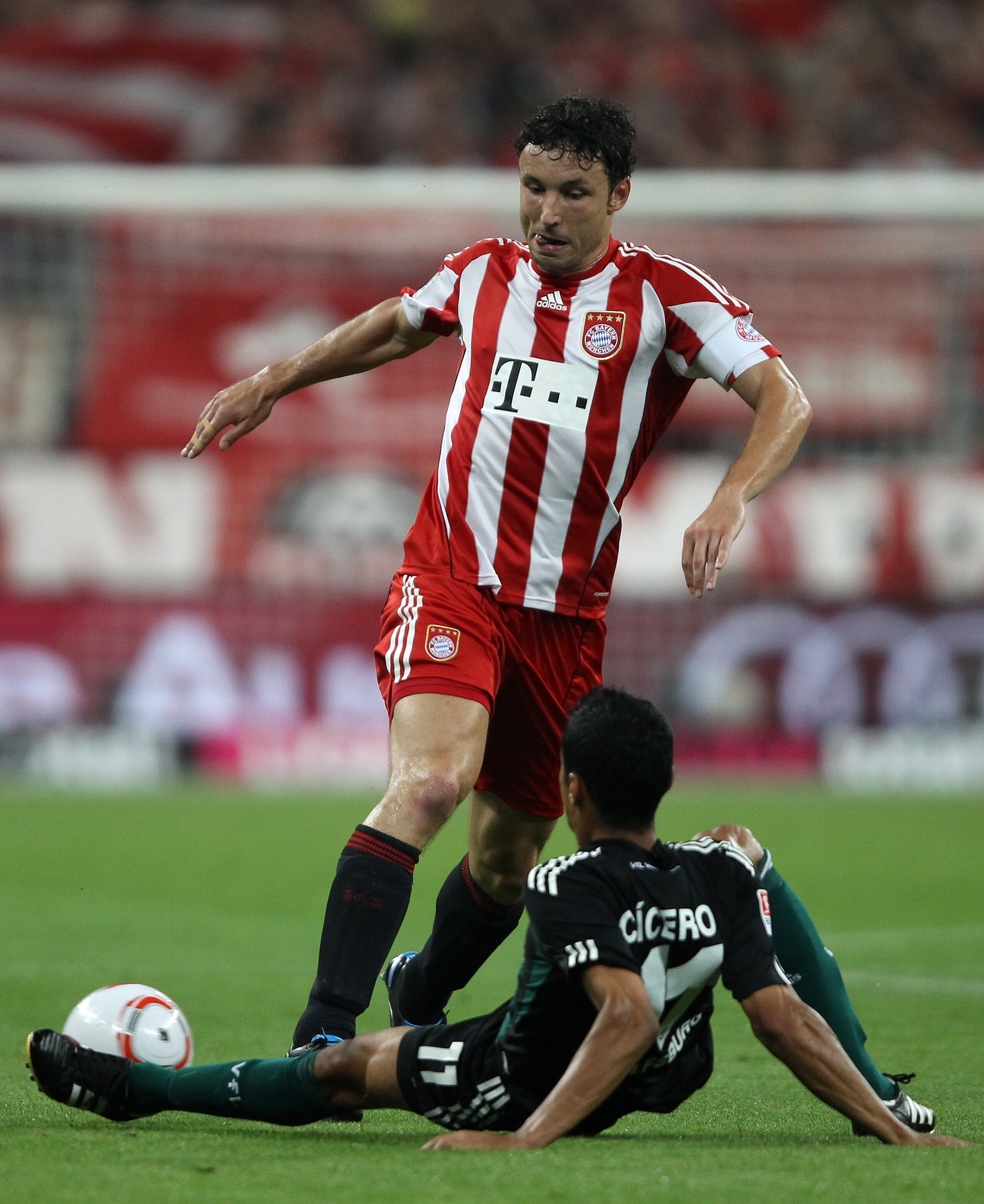 MUNICH, GERMANY - AUGUST 20: Mark van Bommel of Bayern is challenged by Cicero of Wolfsburg during the Bundesliga match between FC Bayern Muenchen and VfL Wolfsburg at Allianz Arena on August 20, 2010 in Munich, Germany.  (Photo by Clive Brunskill/Getty I