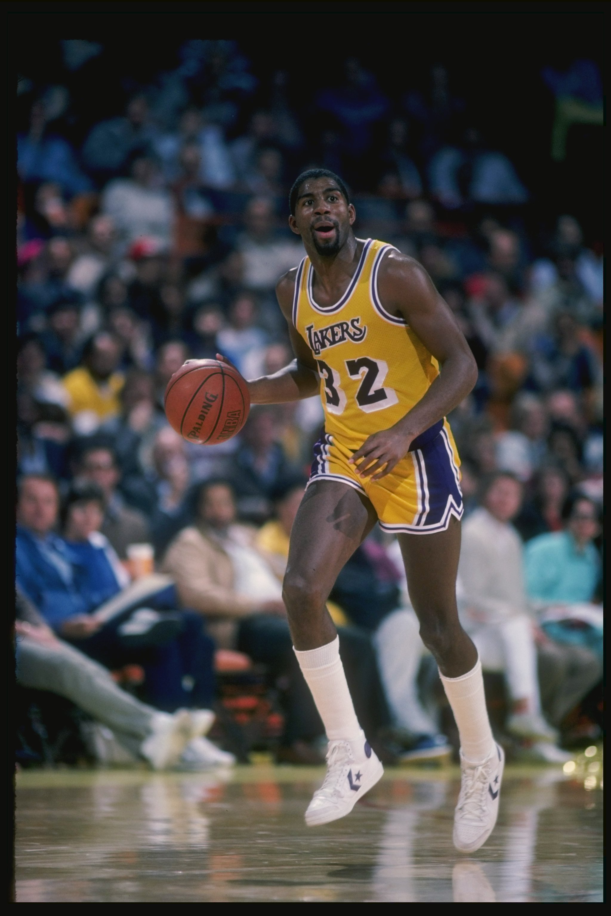 Guard Magic Johnson of the Los Angeles Lakers driibbles the ball down the court during a game at the Great Western Forum in Inglewood, California.