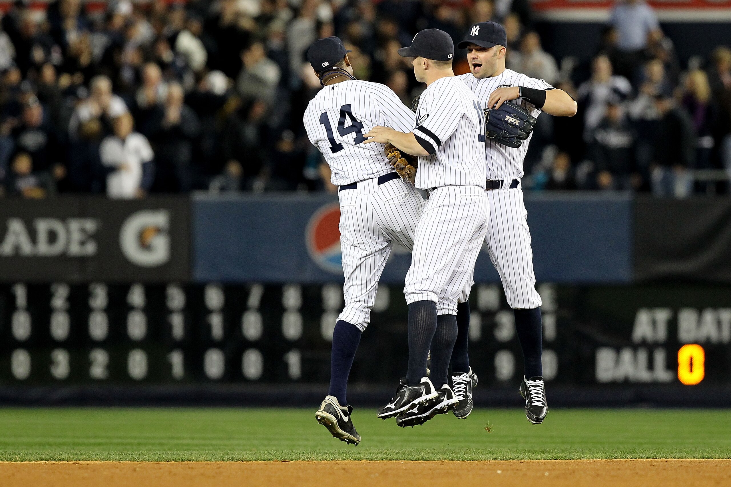NEW YORK - OCTOBER 20:  Curtis Granderson #14, Brett Gardner #11 and Nick Swisher #33 of the New York Yankees celebrate after the Yankees won 7-2 against the Texas Rangers in Game Five of the ALCS during the 2010 MLB Playoffs at Yankee Stadium on October