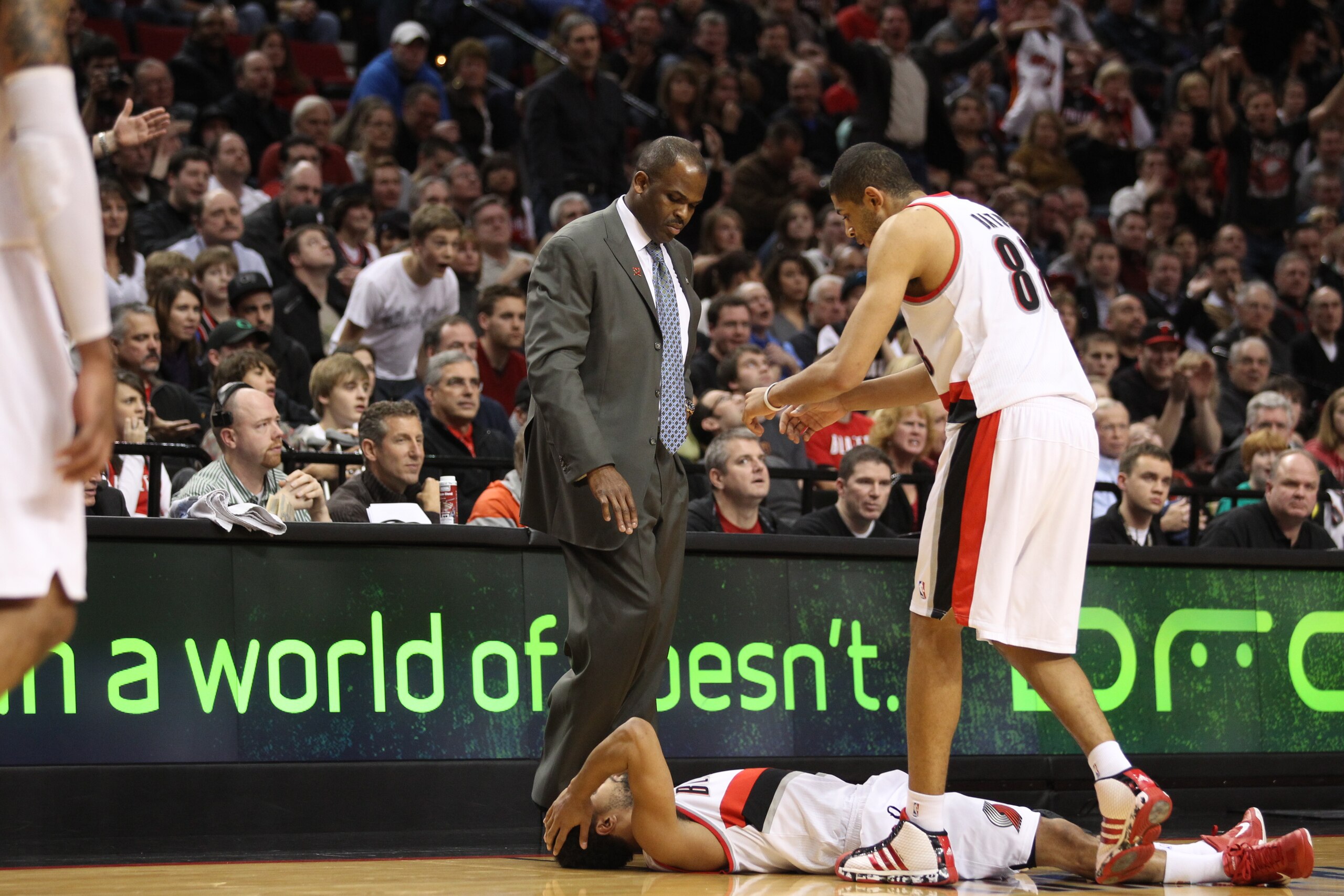 PORTLAND, OR - JANUARY 09: Nicolas Batum #88 and coach Nate McMillan go to help teammate Patrick Mills #8 of the Portland Trail Blazers during the game against the Miami Heat during a game on January 9, 2011 at the Rose Garden Arena in Portland, Oregon. N