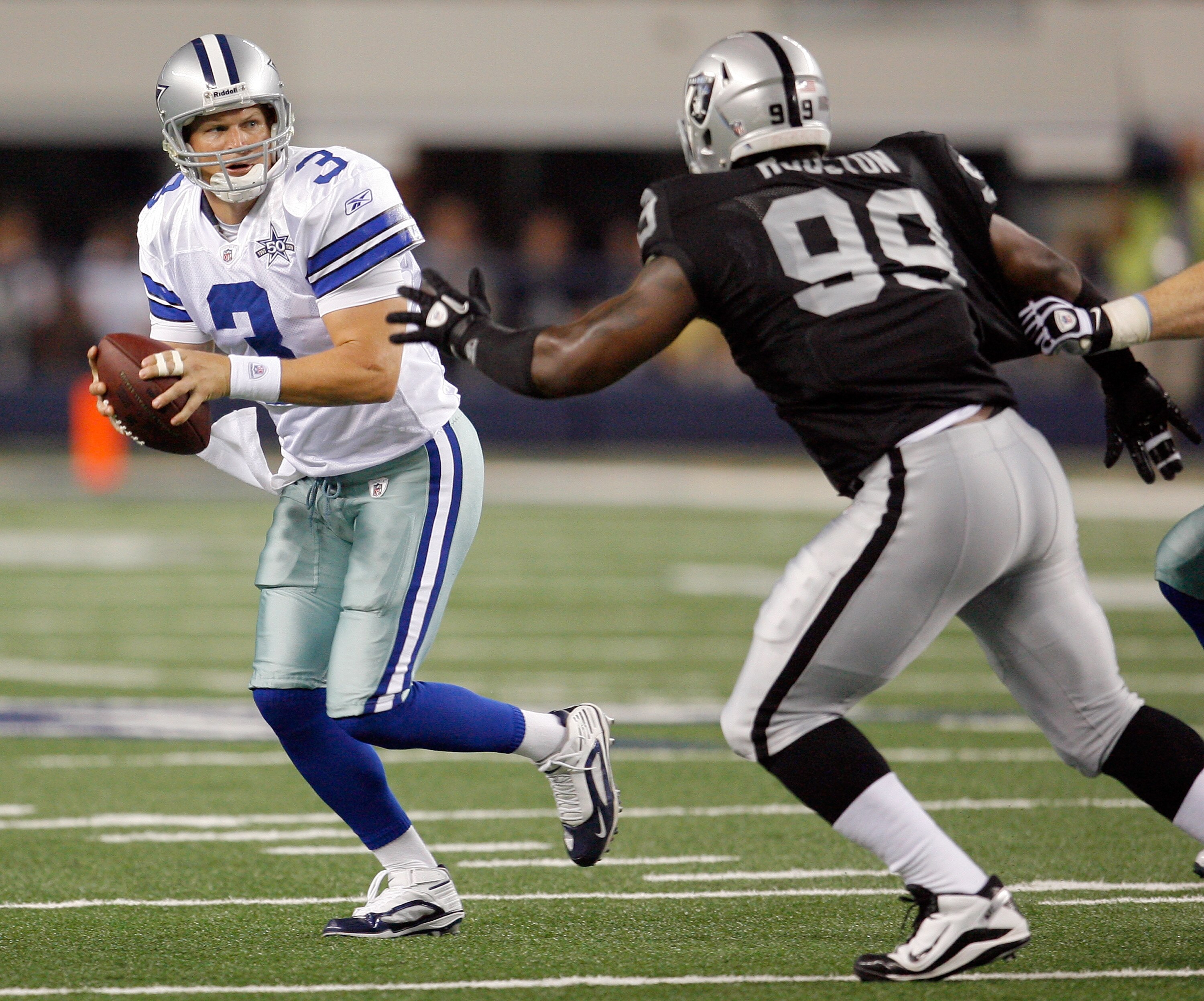 ARLINGTON, TX - AUGUST 12: Jon Kitna #3 of the Dallas Cowboys looks to pass against Lamarr Houston #99 of the Oakland Raiders during the preseason game at the Dallas Cowboys Stadium on August 12, 2010 in Arlington, Texas. (Photo by Tom Pennington/Getty Im