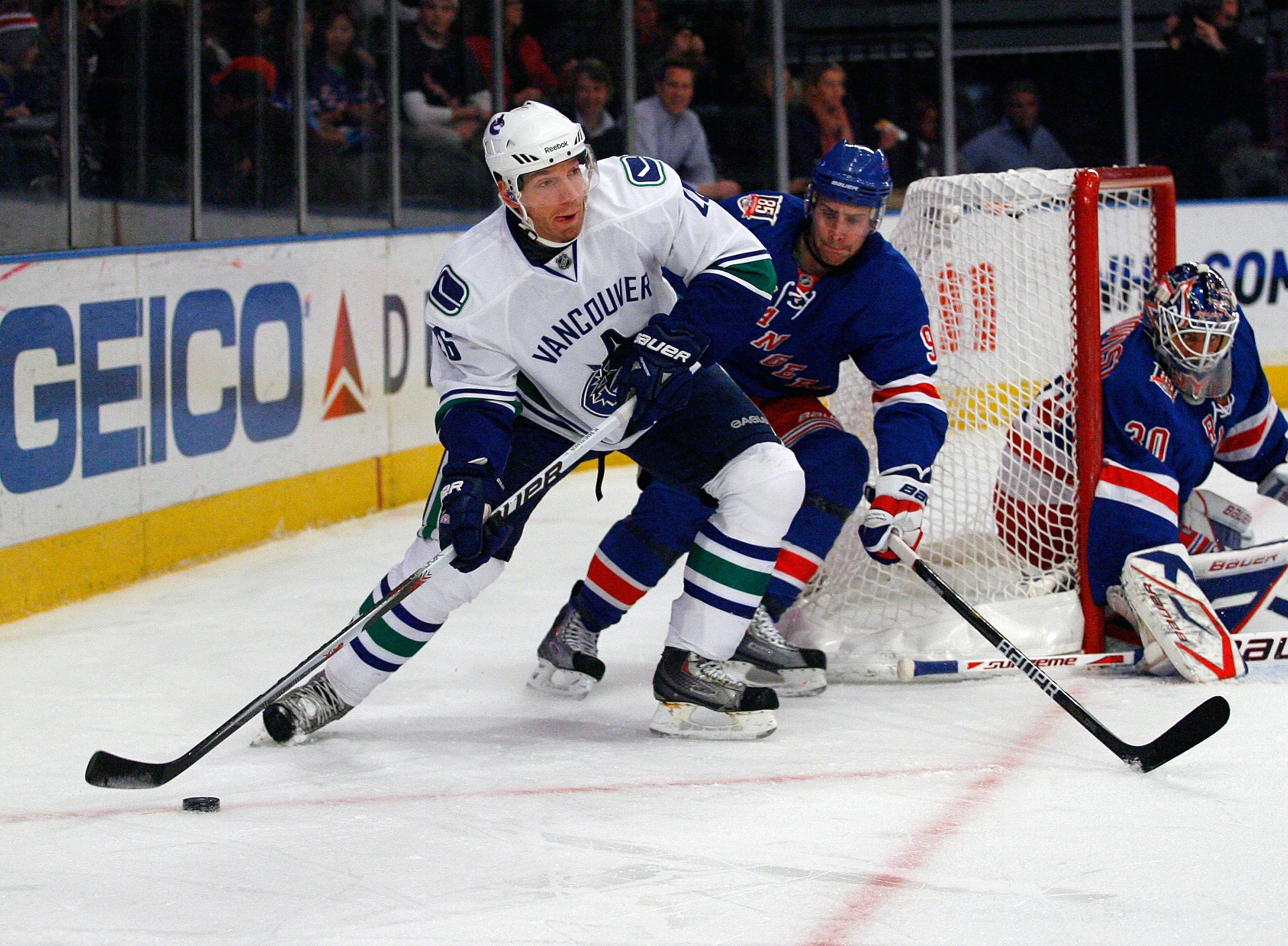 NEW YORK , NY - JANUARY 13: Mikael Samuelsson #26 of the Vancouver Canucks plays the puck away from Matt Gilroy #97 of the New York Rangers during the game at Madison Square Garden on January 13, 2011 in New York City. (Photo by Andy Marlin/Getty Images)