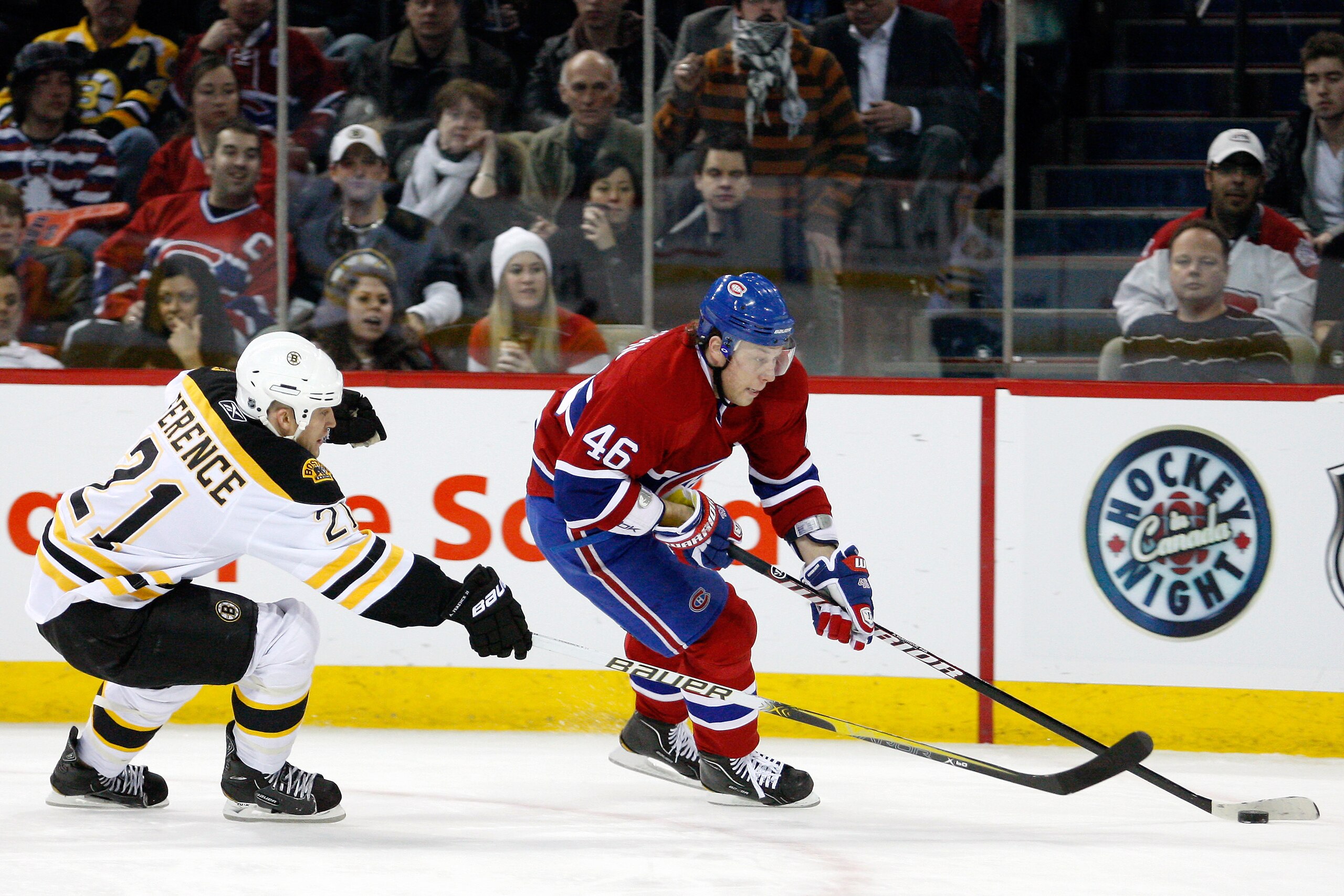 MONTREAL, CANADA - JANUARY 8:  Andrei Kostitsyn #46 of the Montreal Canadiens skates with the puck while being defended by Andrew Ference #21 of the Boston Bruins during the NHL game at the Bell Centre on January 8, 2011 in Montreal, Quebec, Canada.  The