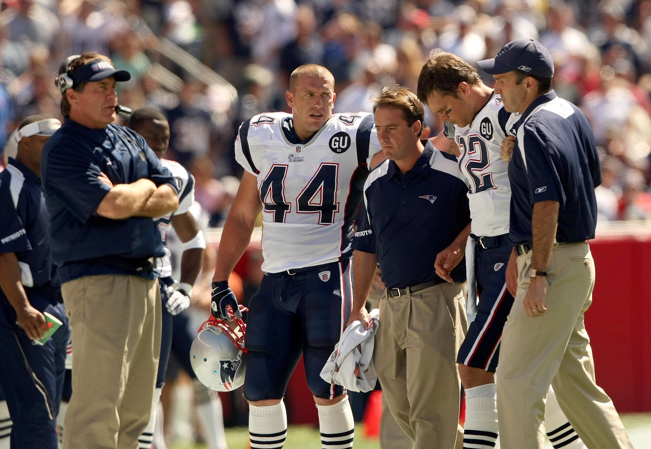 FOXBORO, MA - SEPTEMBER 7:  Quarterback Tom Brady #12 of the New England Patriots walks off the field with the aid of the Patriots staff after being injured on a play as Head Coach Bill Belichick looks on from the sideline during their NFL game against th