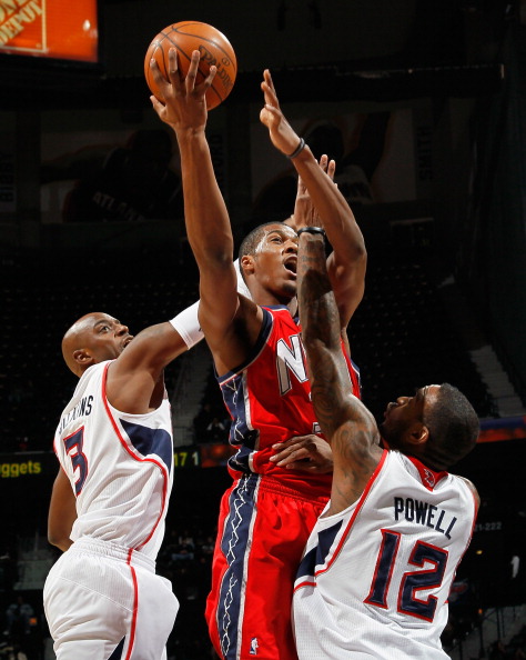 ATLANTA, GA - DECEMBER 07:  Damien Wilkins #3 and Josh Powell #12 of the Atlanta Hawks defend the basket against Derrick Favors #14 of the New Jersey Nets at Philips Arena on December 7, 2010 in Atlanta, Georgia.  NOTE TO USER: User expressly acknowledges